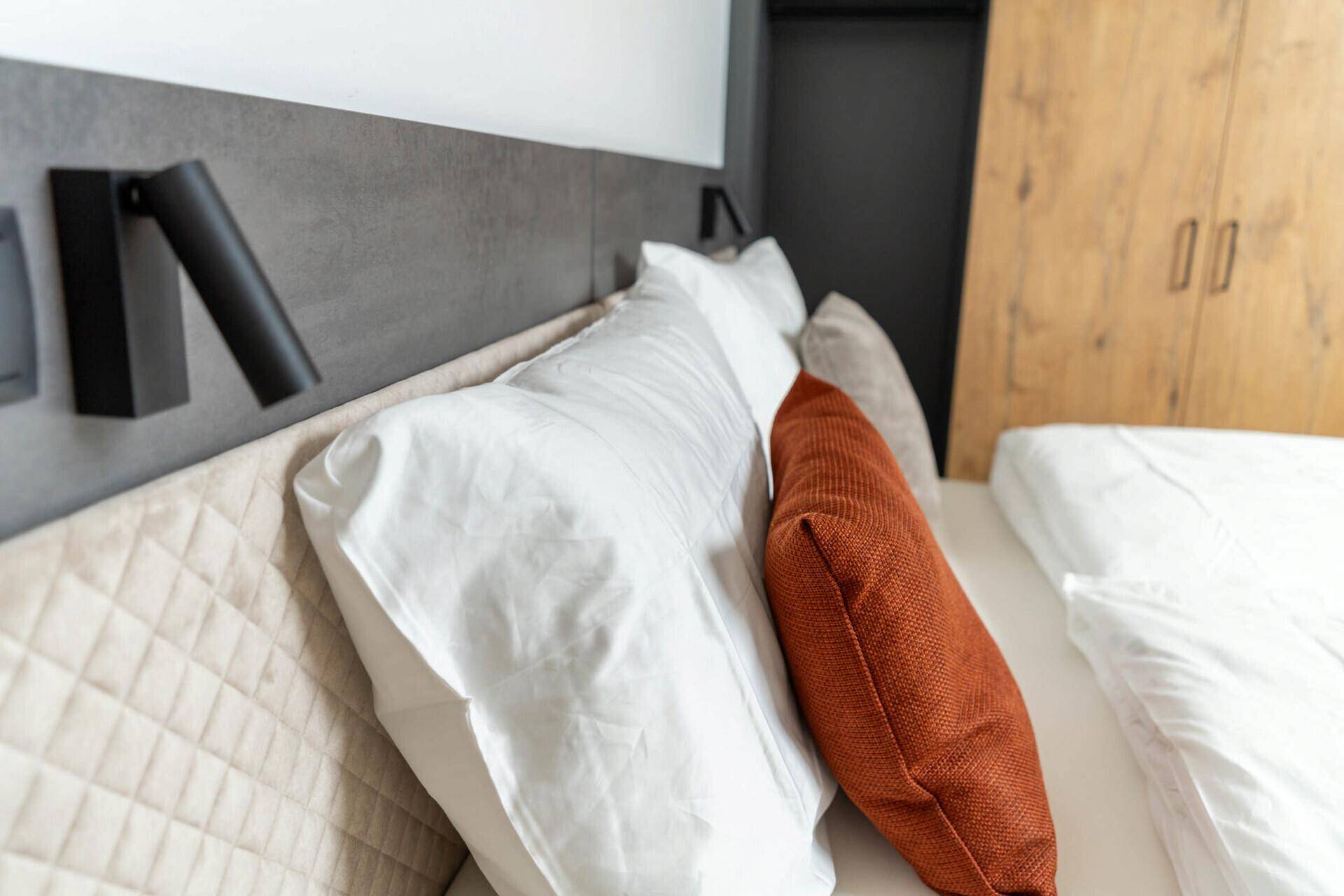 Heller Wohnbereich mit großen Fenstern, Holzboden und Treppenzugang.