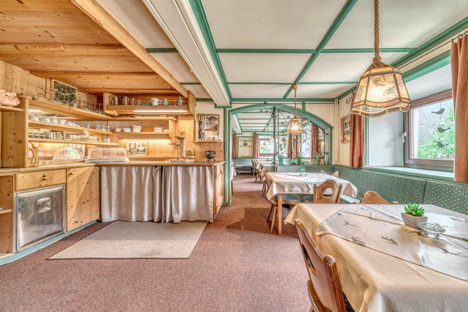 Speisesaal mit Buffetbereich, Holztäfelung und traditionellen Sitzgelegenheiten.