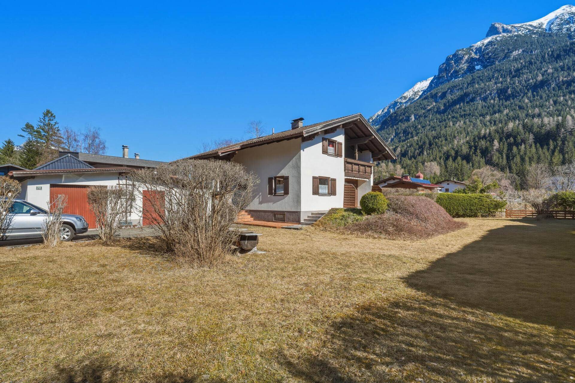 Haus mit großem Garten, Rasenfläche und beeindruckendem Bergblick.