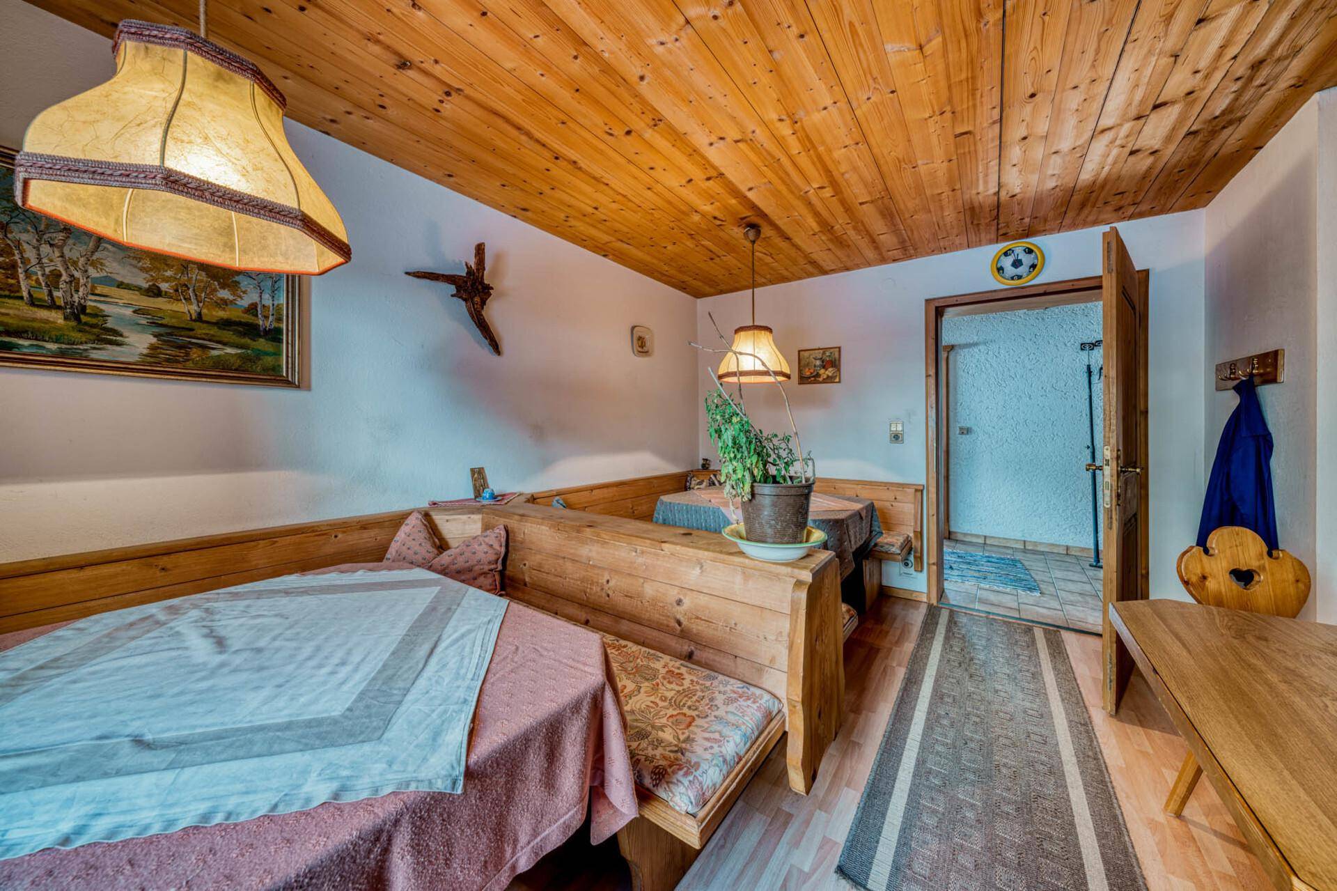 Traditioneller Essbereich mit Holzbänken, Holztisch und rustikaler Dekoration.