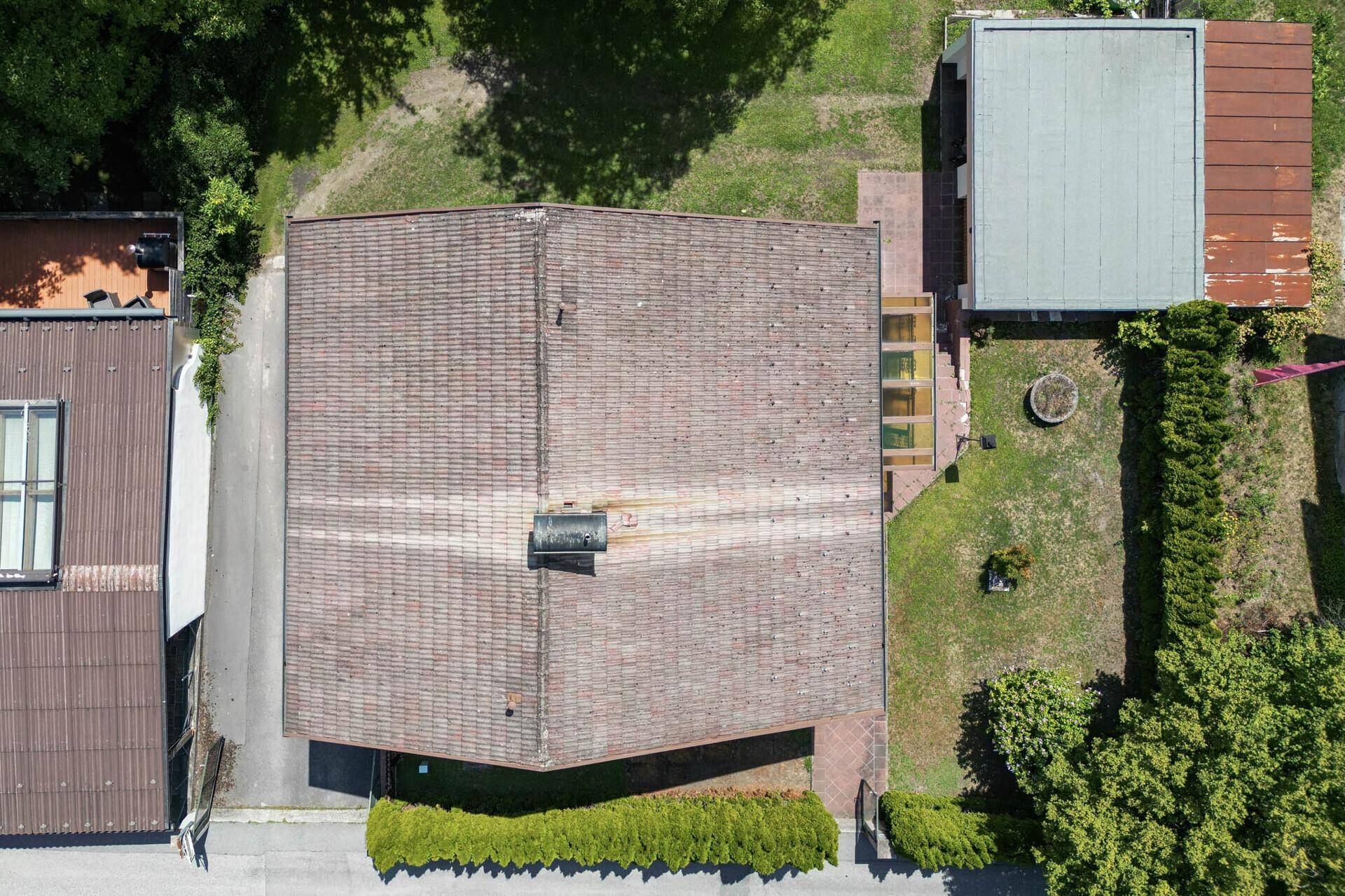 Draufsicht auf das Haus mit Satteldach, Garten und angrenzenden Gebäuden.