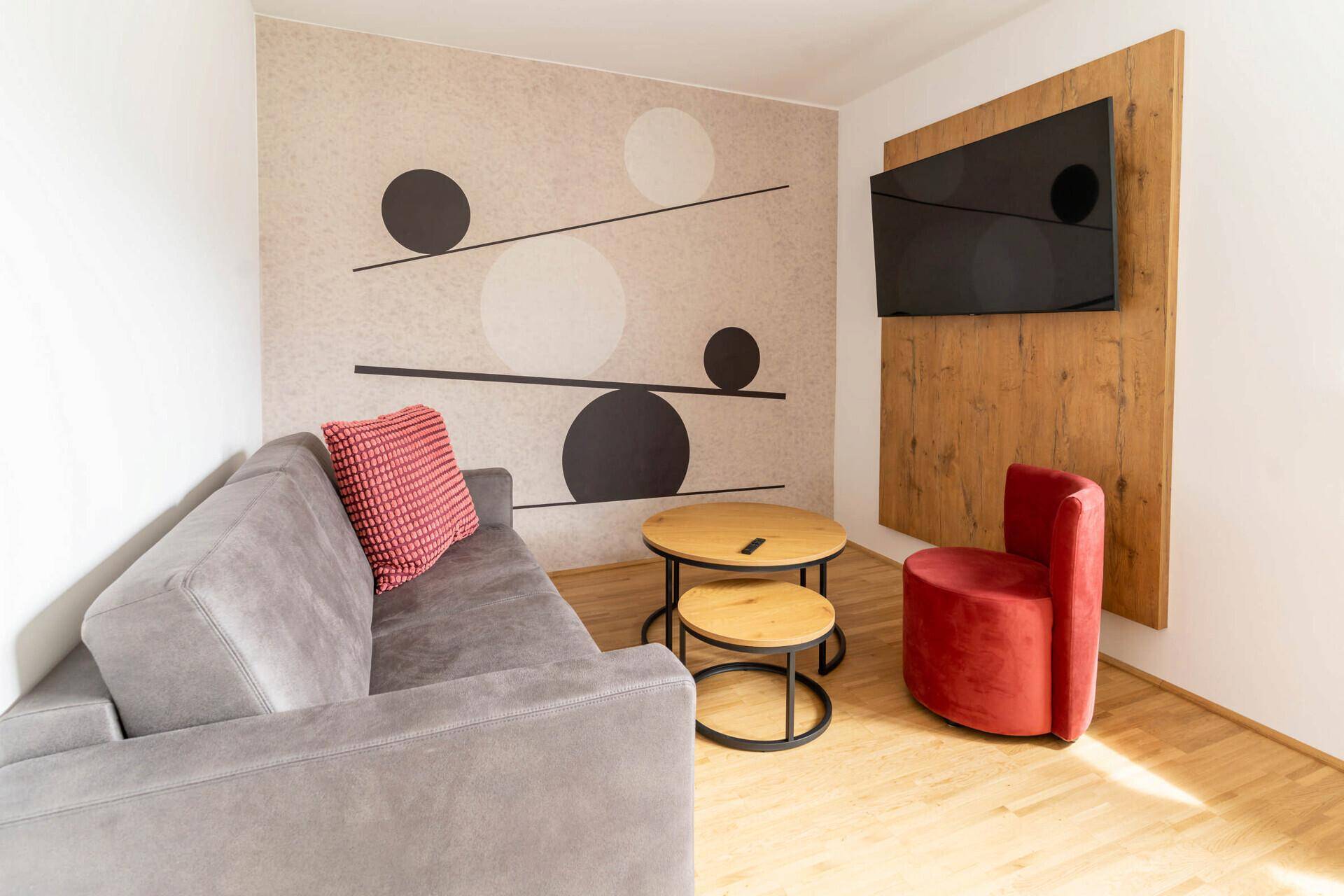 Heller Wohn-Essbereich mit Holzboden, Esstisch und dekorativer Wandgestaltung.