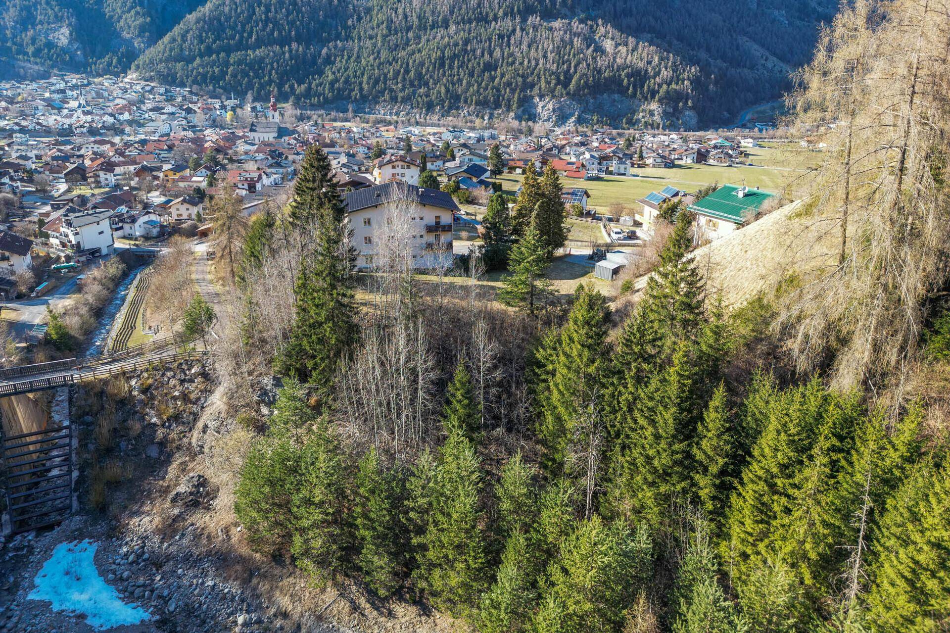 Luftaufnahme des Wohnhauses mit Blick auf das Dorf und die Berge.