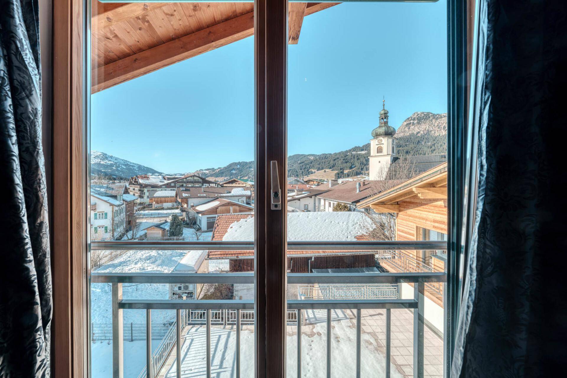 Blick aus dem Schlafzimmerfenster auf die verschneite Stadt und die Kirche.