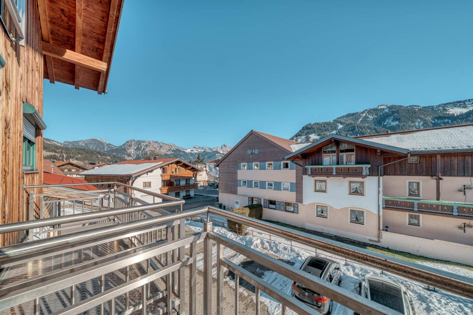 Balkon mit Edelstahlgeländer und weitem Blick auf die verschneite Berglandschaft.