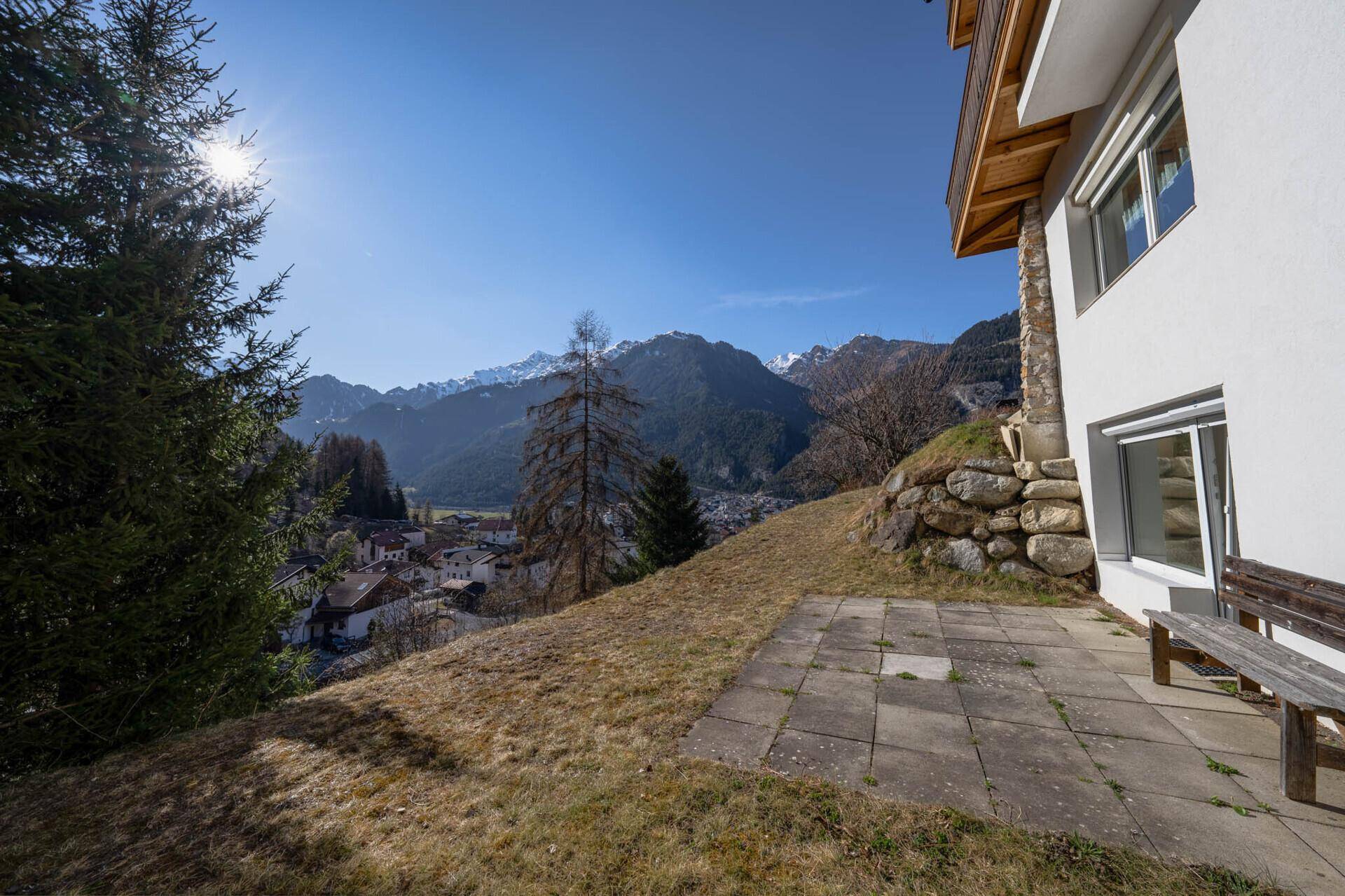 Sonniger Terrassenbereich mit Blick auf die Berge und das Tal.