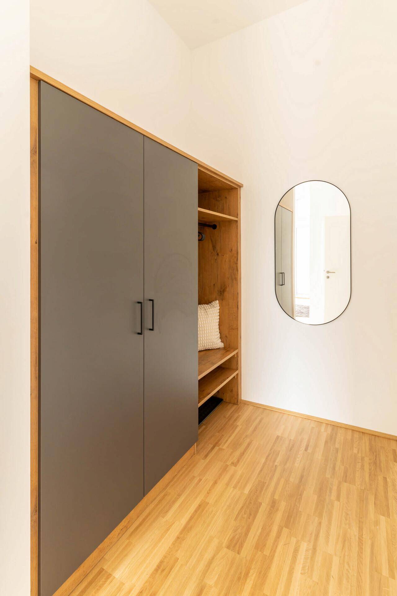 Modernes Gäste-WC mit Wand-WC, kleinem Waschbecken und dunklen Bodenfliesen.