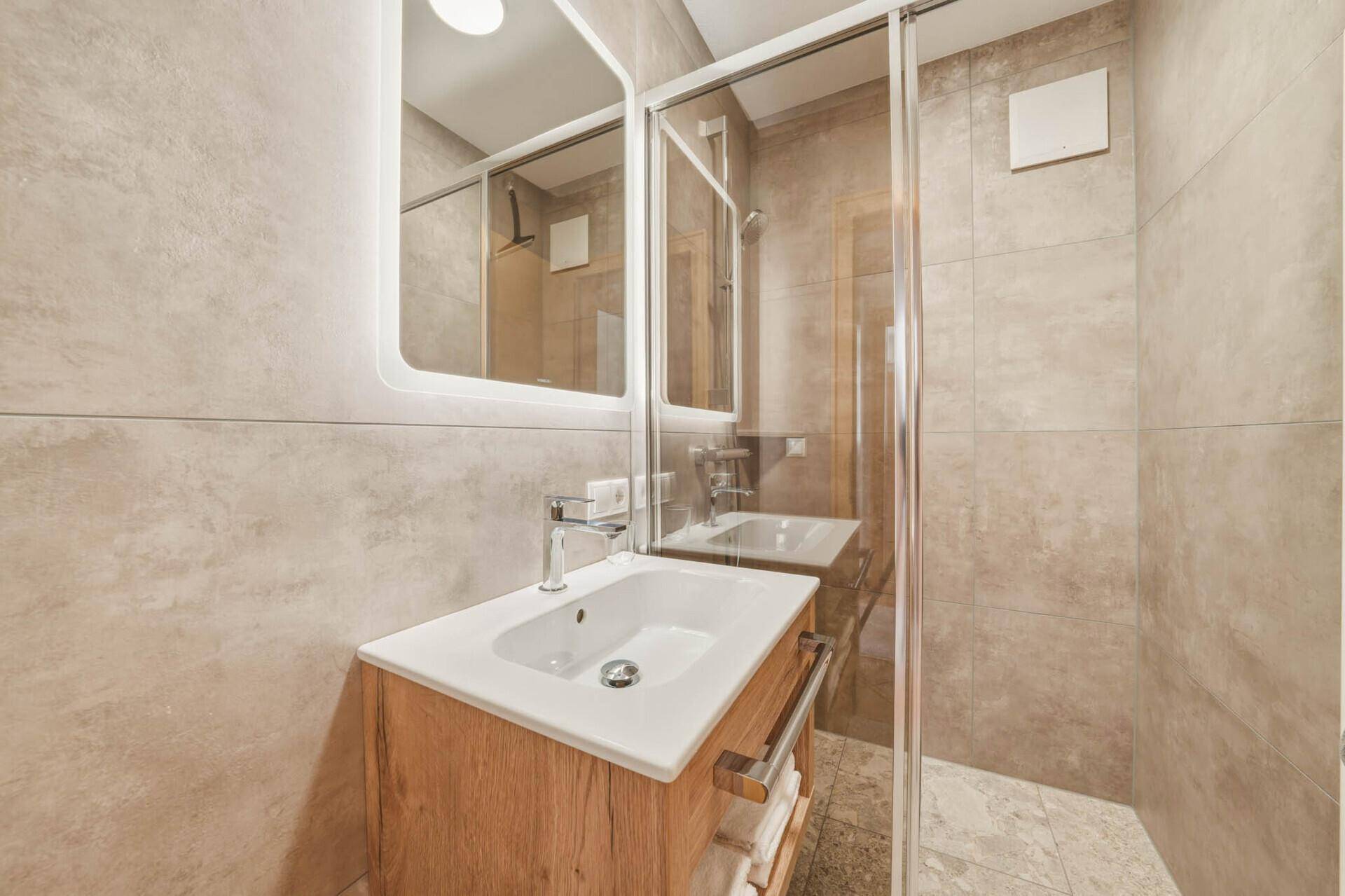 Kleines Badezimmer mit Einzelwaschbecken und moderner Duschkabine.