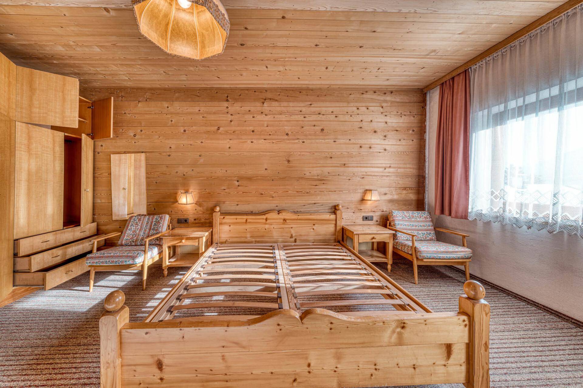 Schlafzimmer im Landhausstil mit Holzvertäfelung, Teppichboden und Einbauschränken.