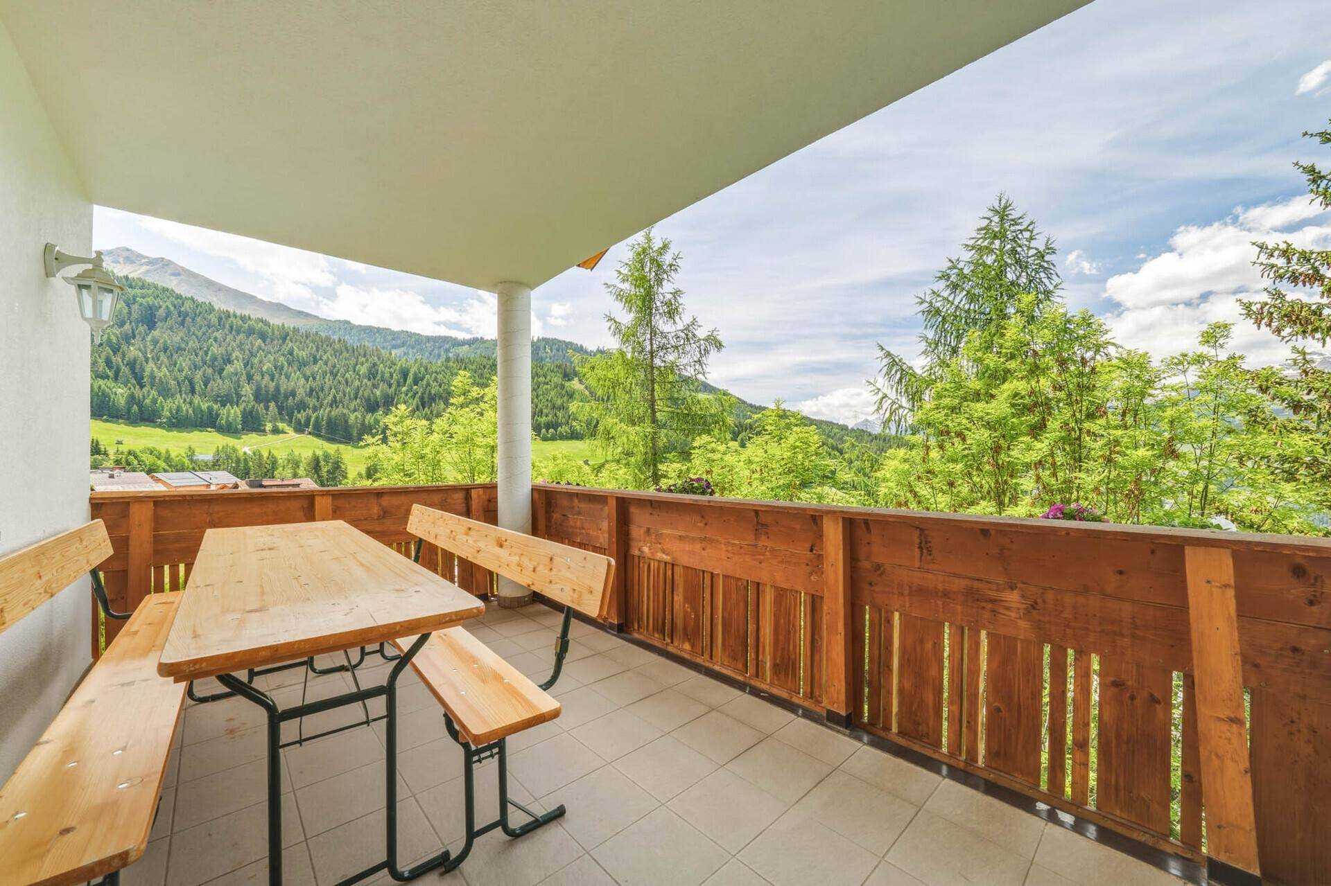 Geräumiger Balkon mit Sitzgelegenheiten und atemberaubendem Panoramablick auf die Berge.