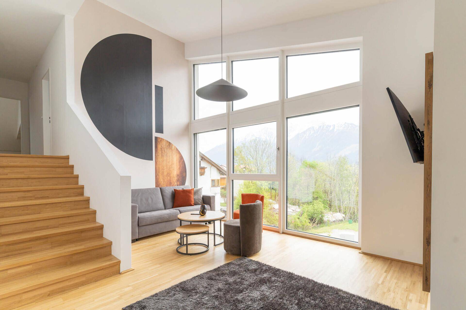 Gemütlicher Wohnbereich mit Sofa, Couchtisch und großen Fenstern.