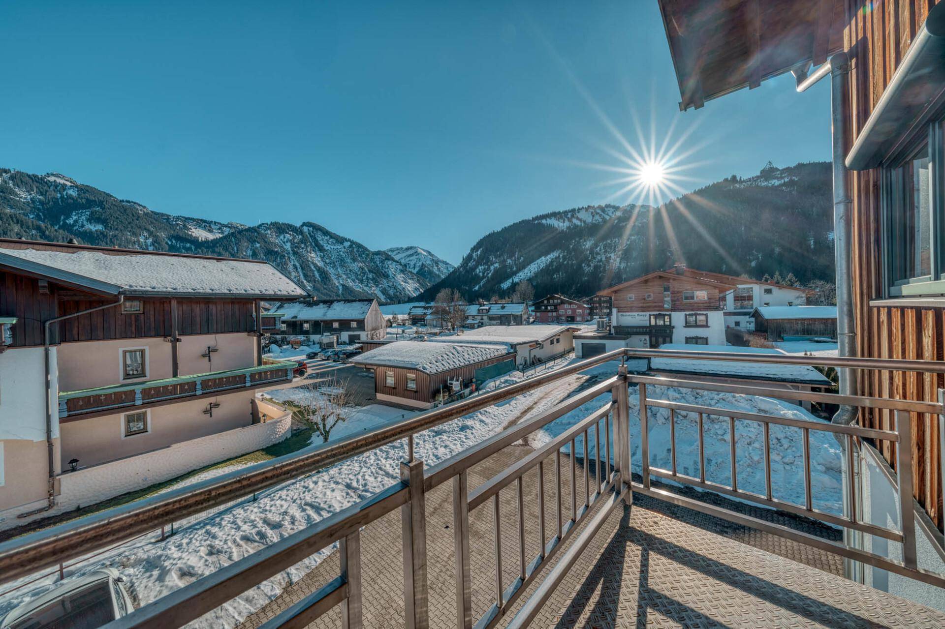 Sonniger Balkon mit Panoramablick auf die umliegenden Berge und das Tal.