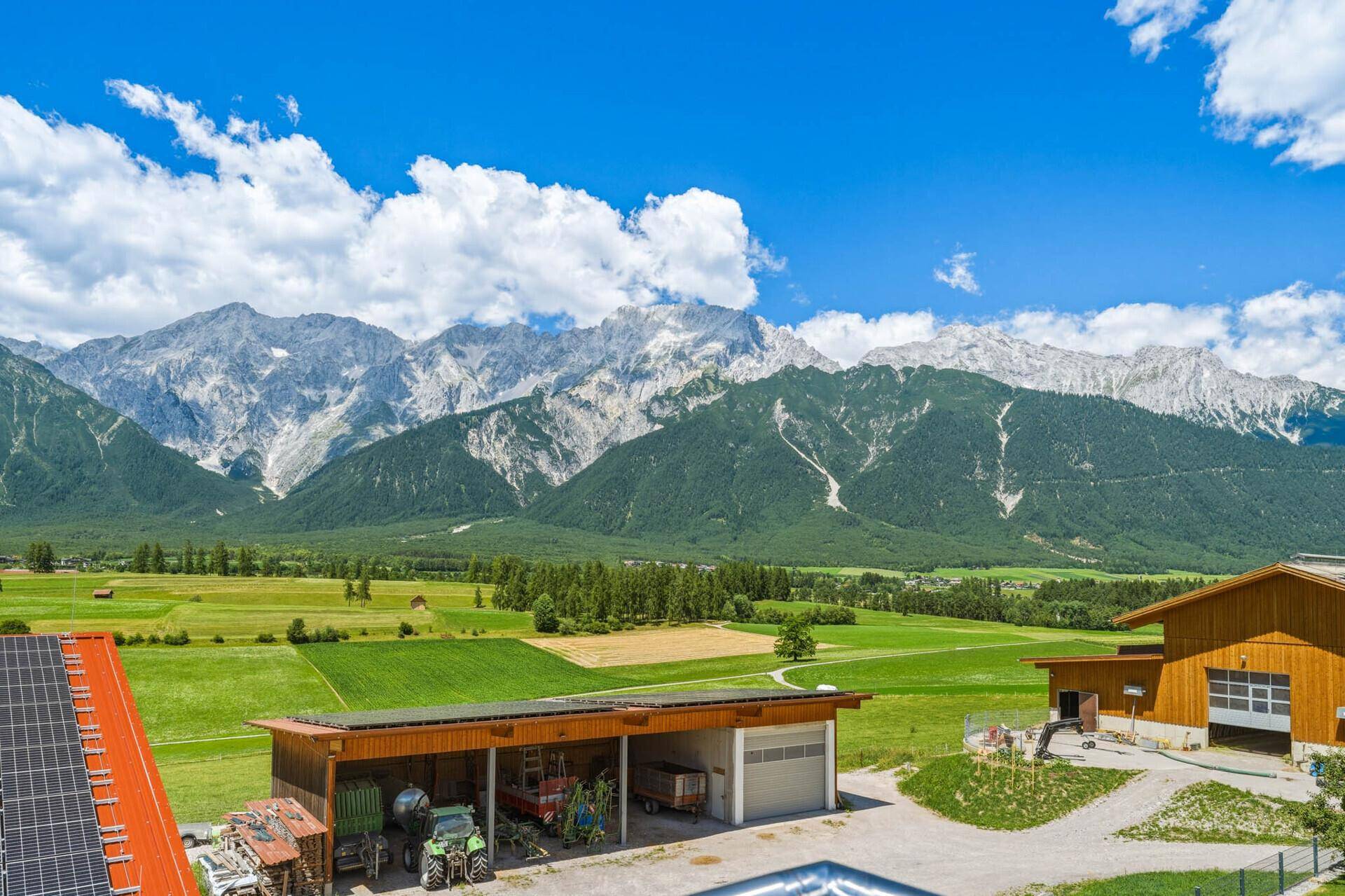 Beeindruckender Blick auf die majestätischen Berge, weite Felder und ländliche Bebauung.