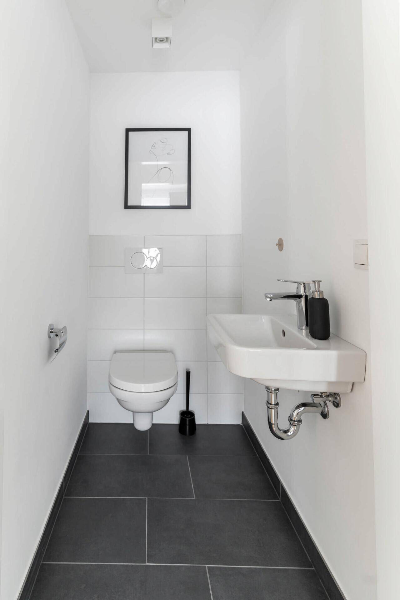 Heller Eingangsbereich mit Holzboden, Garderobenschrank und offenem Regal.