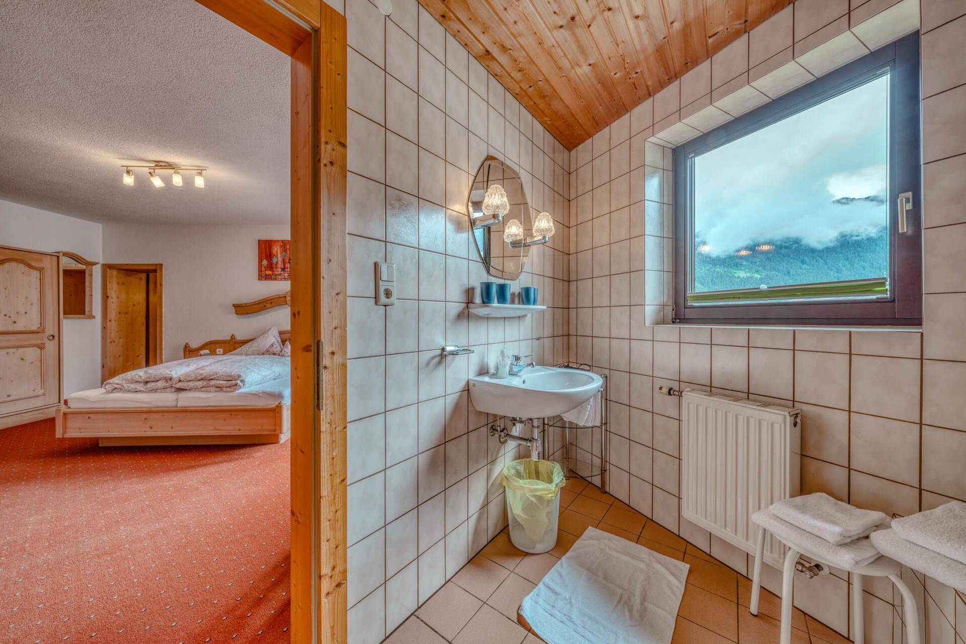 Badezimmer mit Fenster und Blick auf die Berge, direkt vom Schlafzimmer zugänglich.