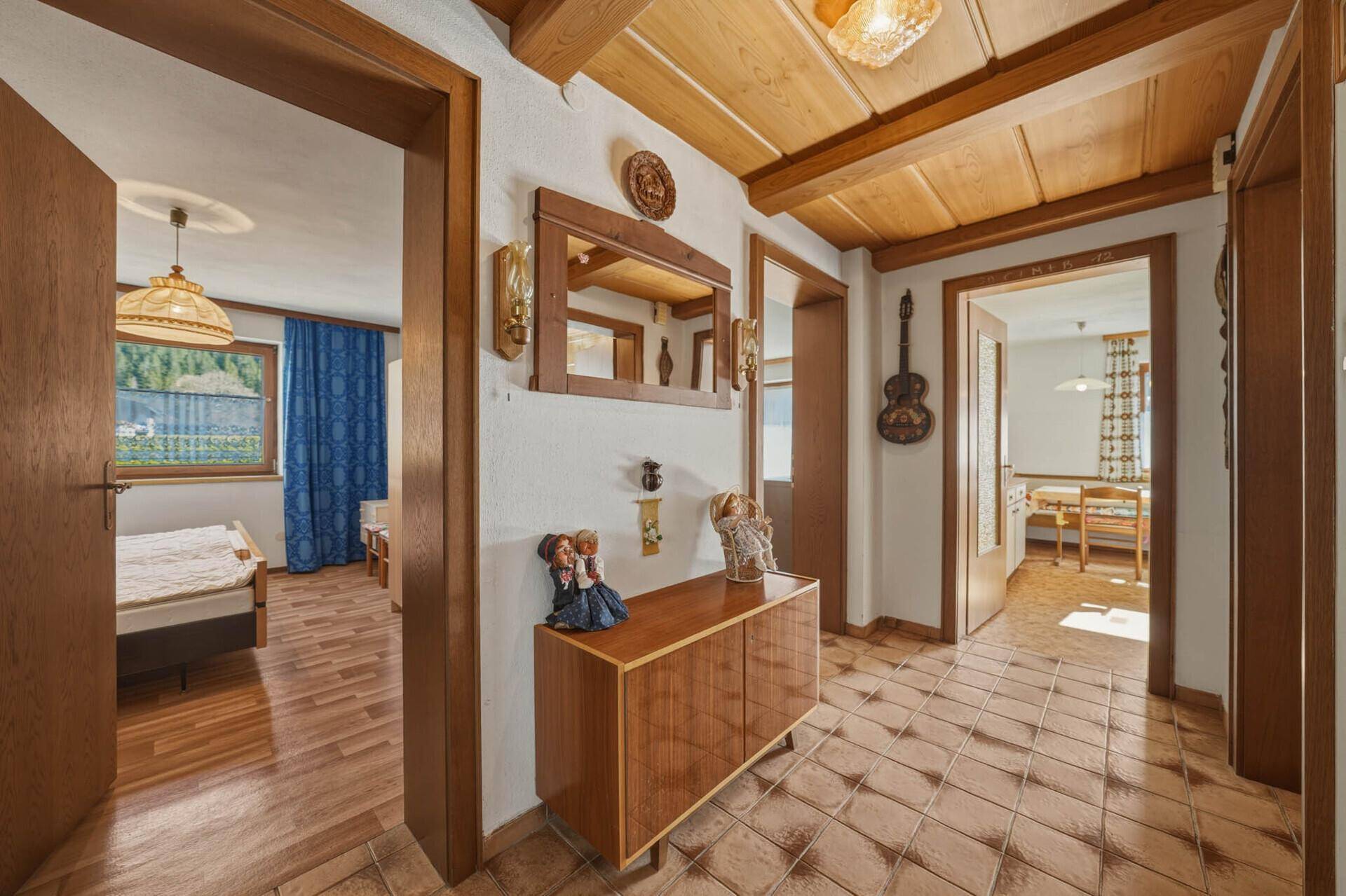 Flur mit Holzdecke und Terrakottafliesen, der Zugang zu Schlafzimmer und Wohnbereich bietet.