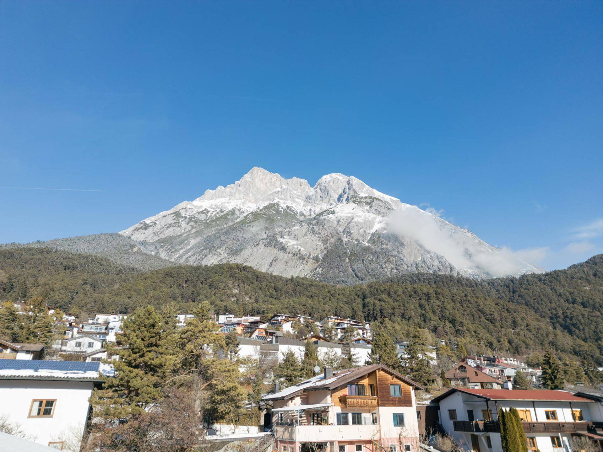Panoramablick auf die majestätischen Berge und die darunter liegende Siedlung.