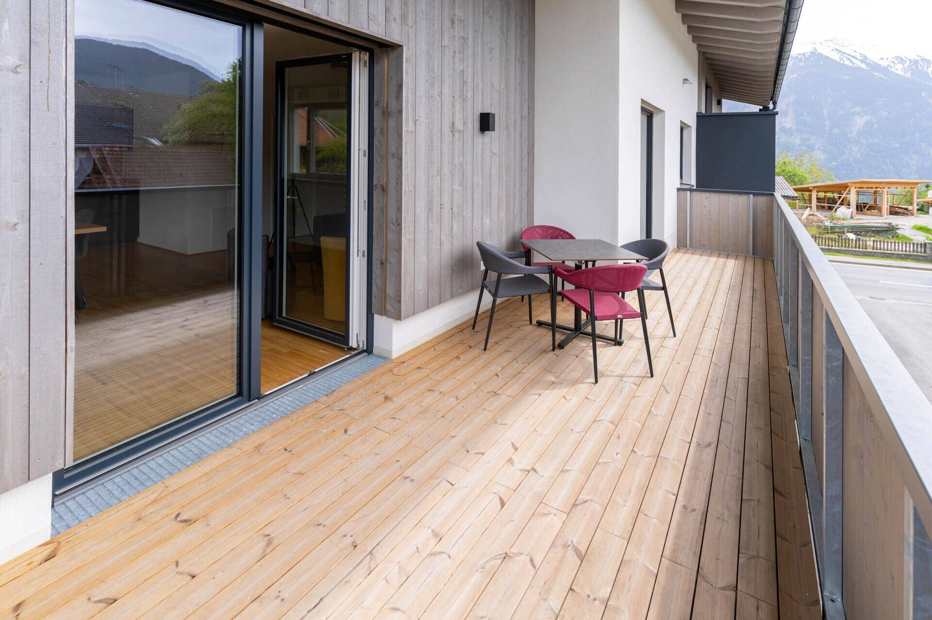 Modernes Gäste-WC mit Wand-WC, kleinem Waschbecken und dunklen Bodenfliesen.