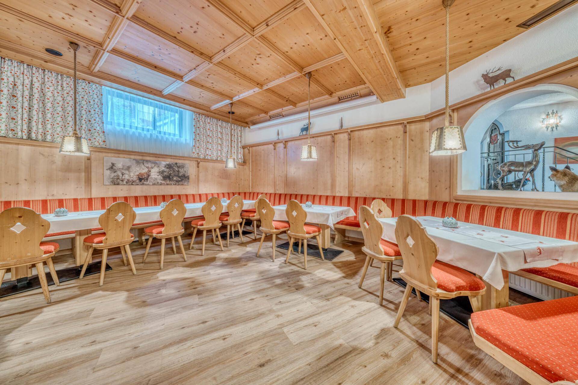 Großer Speisesaal im traditionellen Stil mit Holztäfelung, langen Bänken und Tischen.