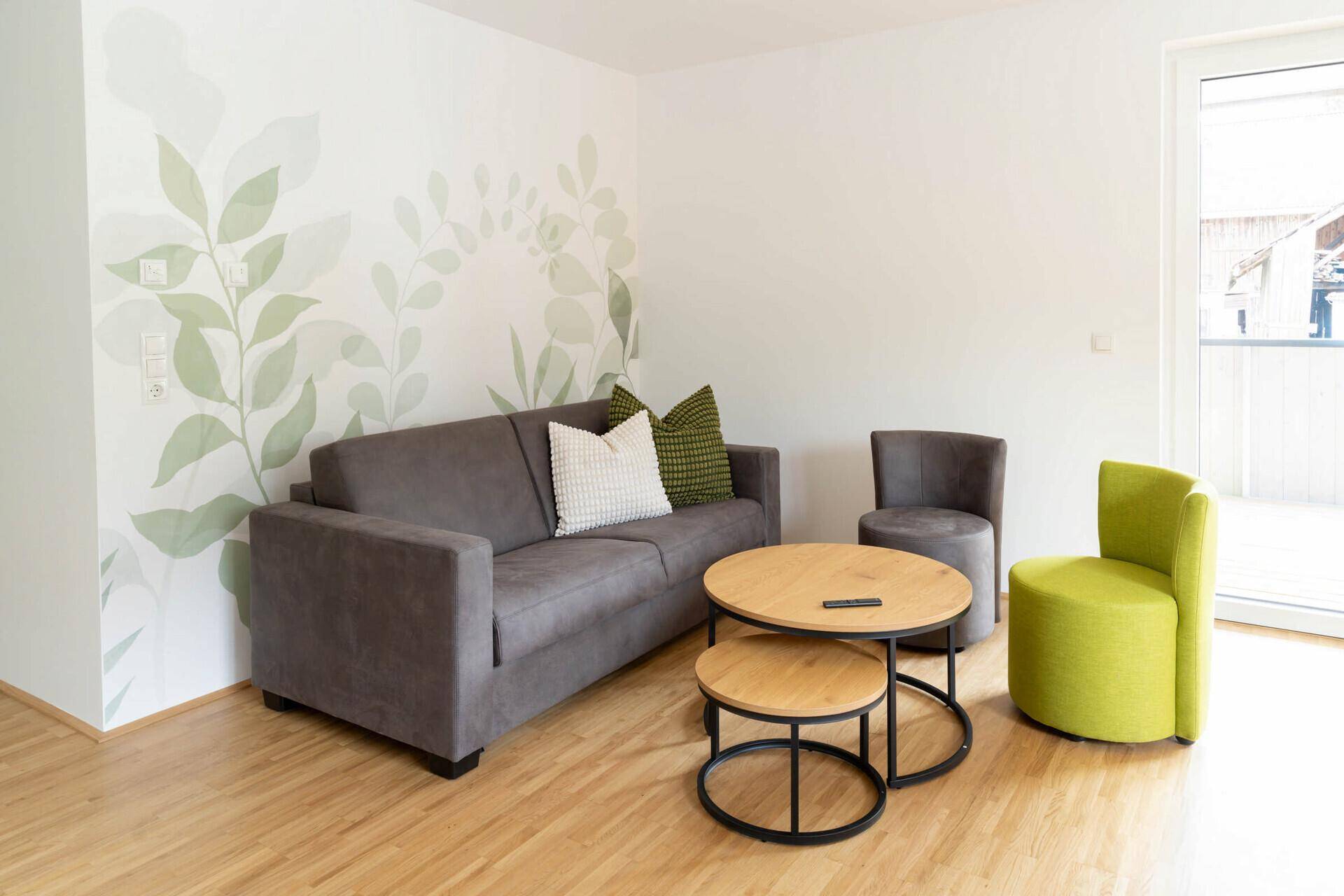 Gemütliches Wohnzimmer mit Sofa, Couchtisch und dekorativer Wandgestaltung.