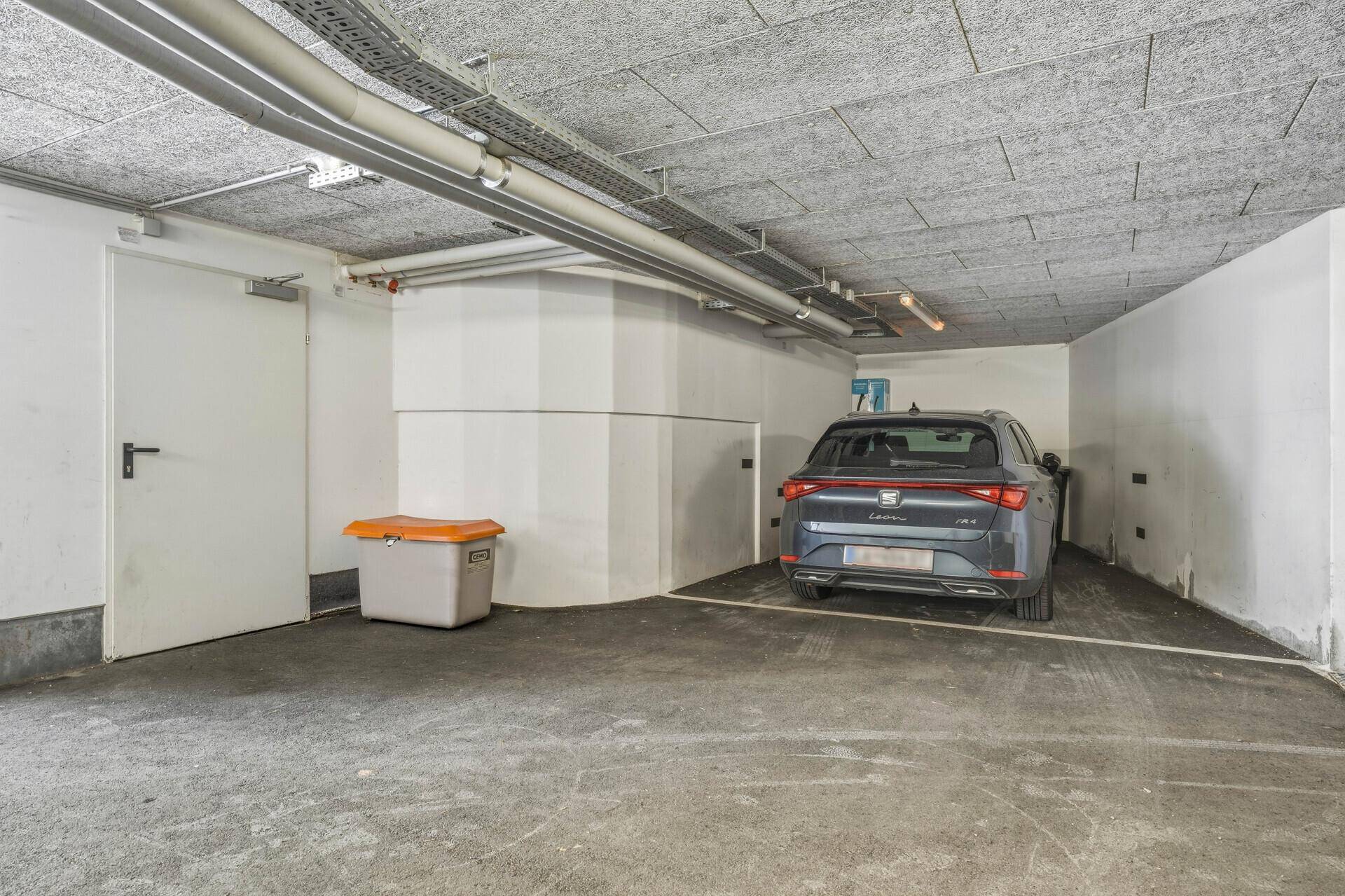 Tiefgarage mit einem geparkten Fahrzeug und zusätzlichem Stauraum.