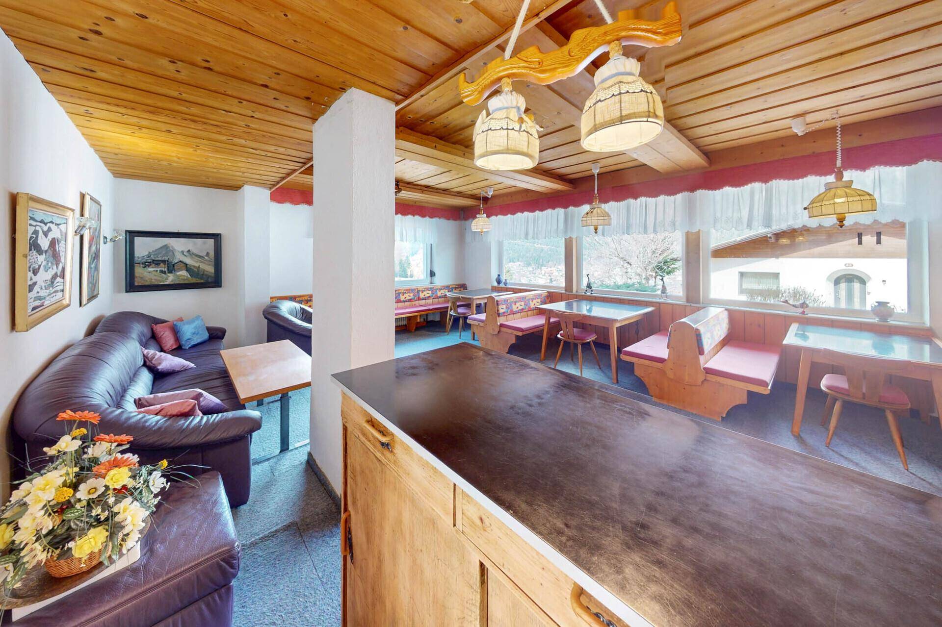 Rustikaler Essbereich mit Holzbänken und Theke, ideal für gesellige Runden.