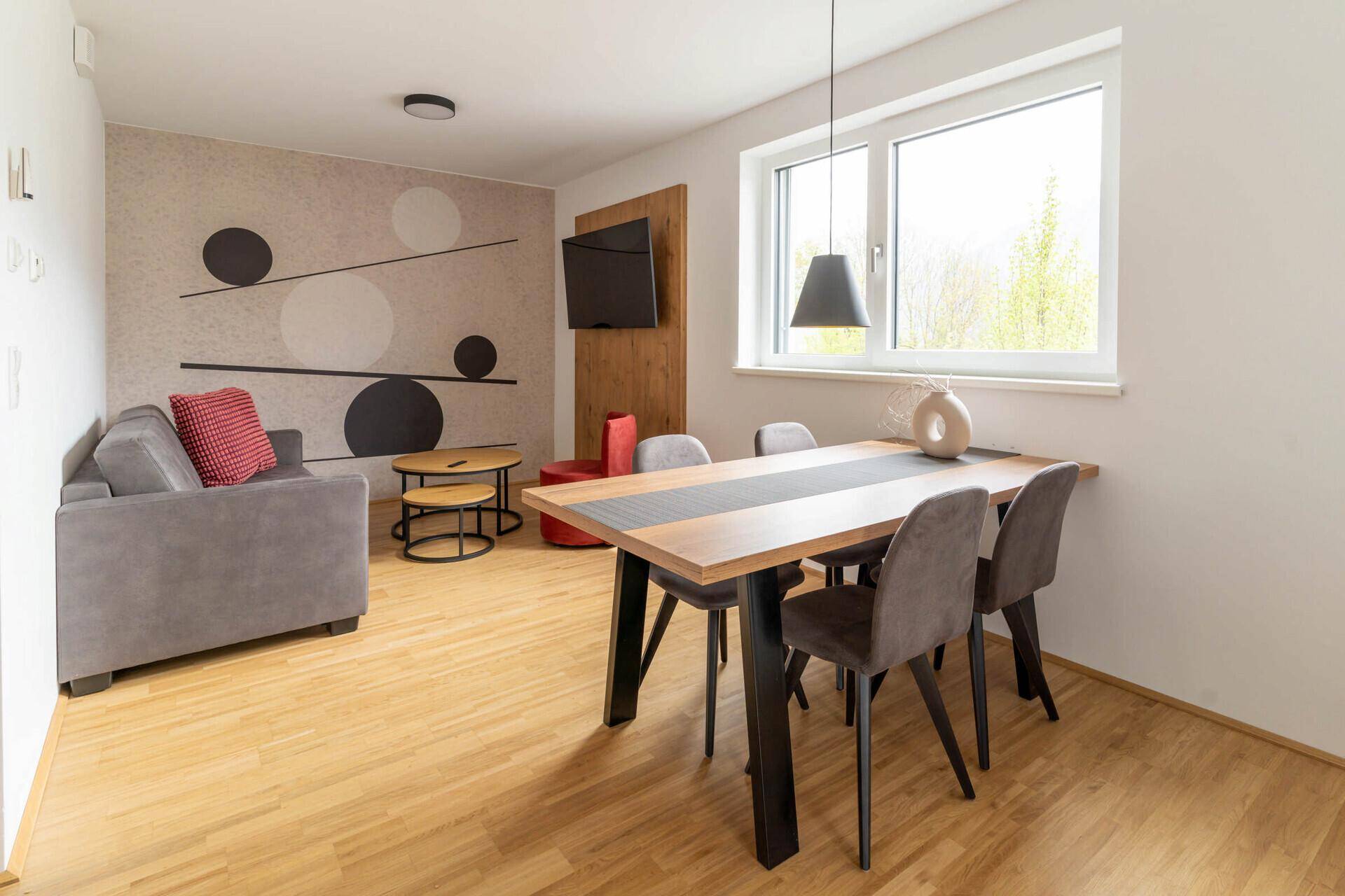 Moderne Küche mit grauen Fronten, Holzarbeitsplatte und integrierten Geräten.