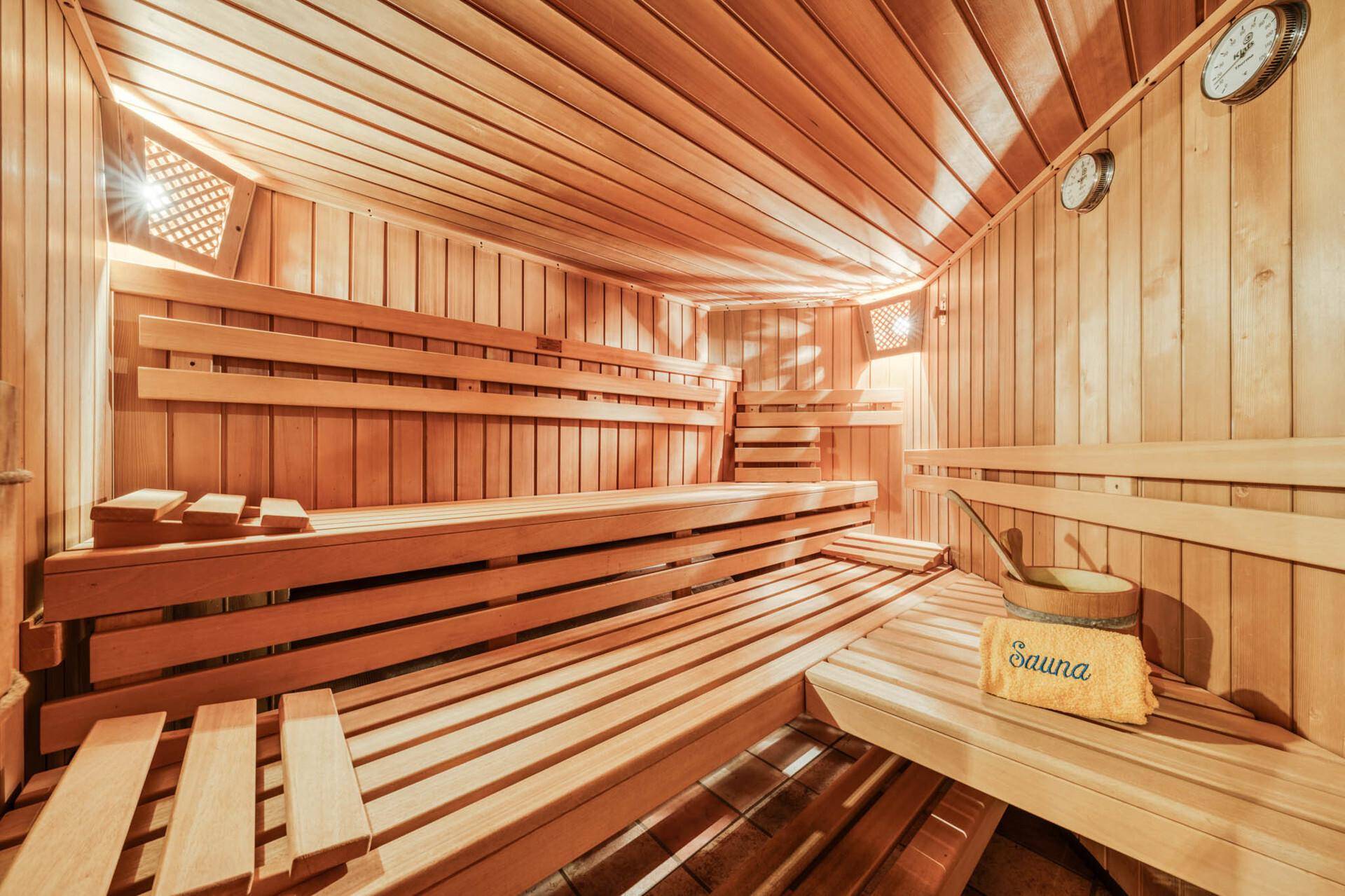 Traditionelle Holzsauna mit mehreren Bänken und klassischem Saunaofen für pure Entspannung.