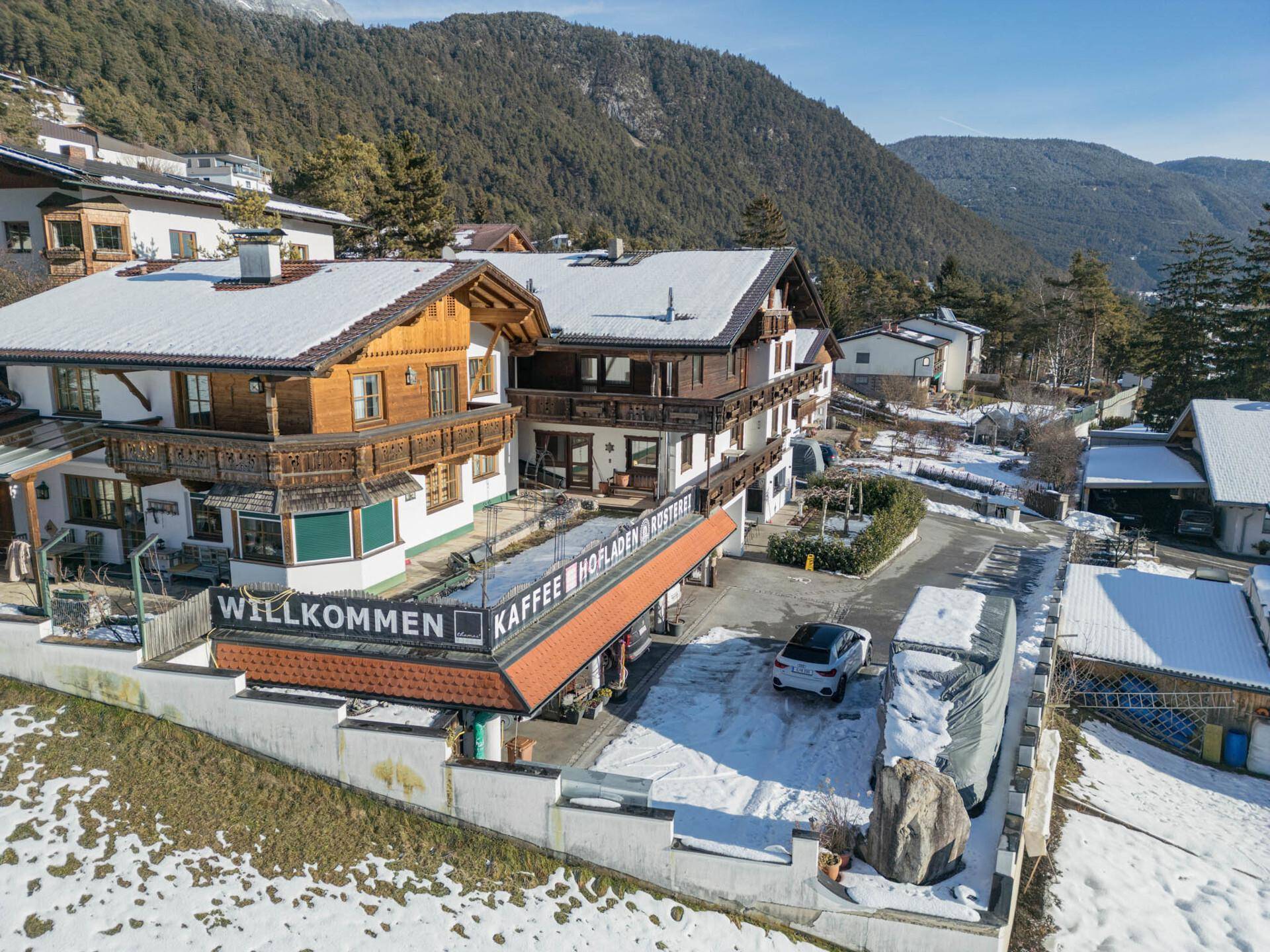 Luftaufnahme des Anwesens mit umliegenden Gebäuden und verschneiter Landschaft.