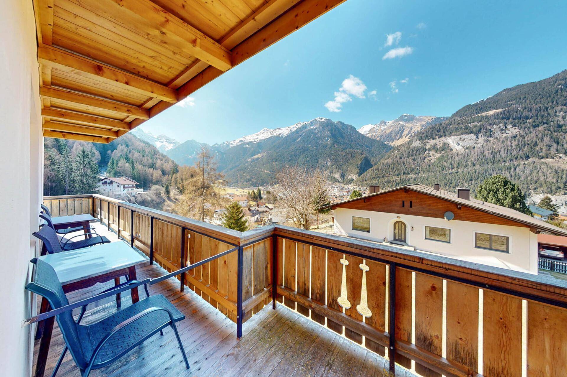 Geräumiger Balkon mit Sitzgelegenheiten und atemberaubendem Blick auf die Berge und das Tal.