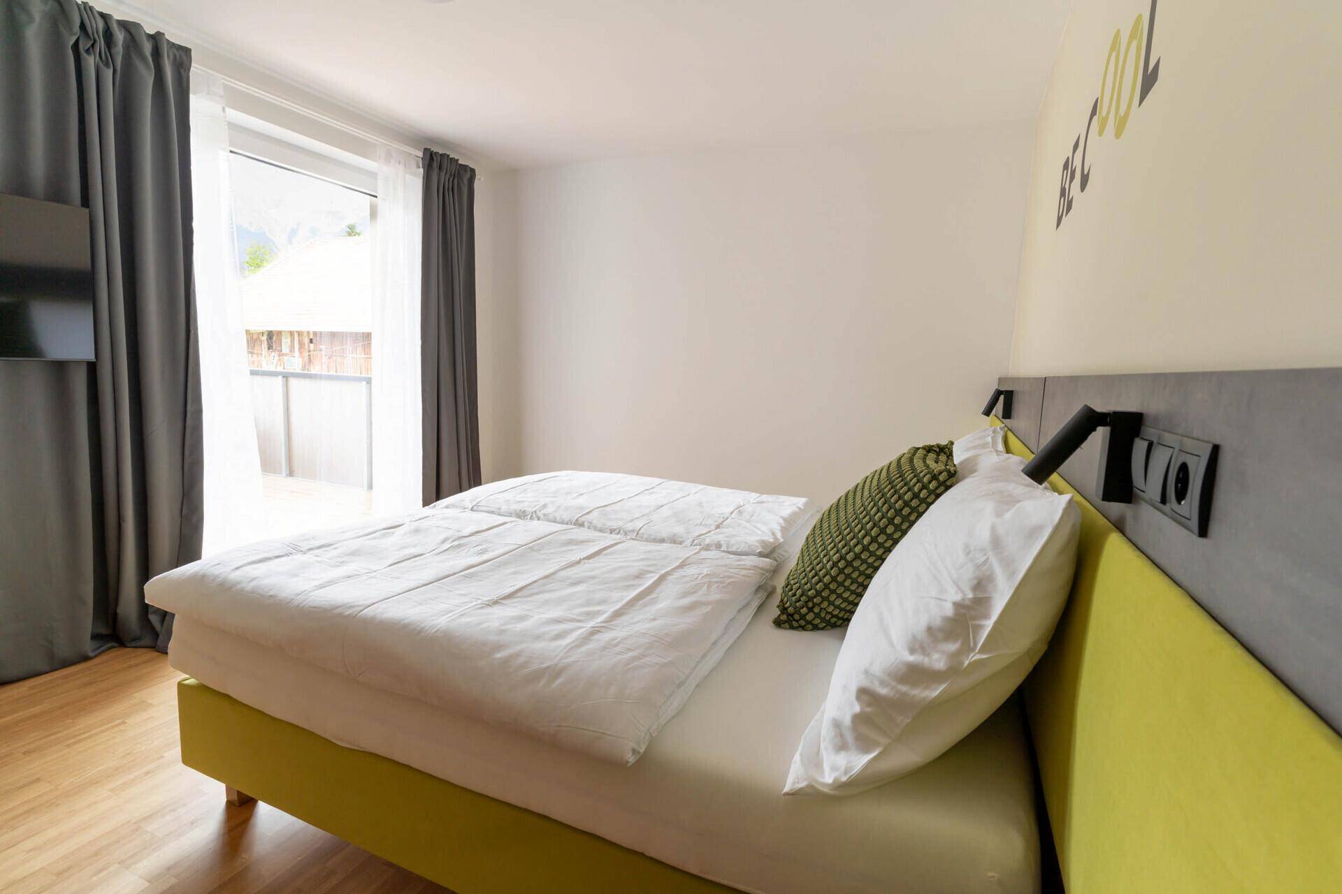 Balkon mit Holzboden, Sitzgelegenheiten und Blick auf die Berge und Umgebung.