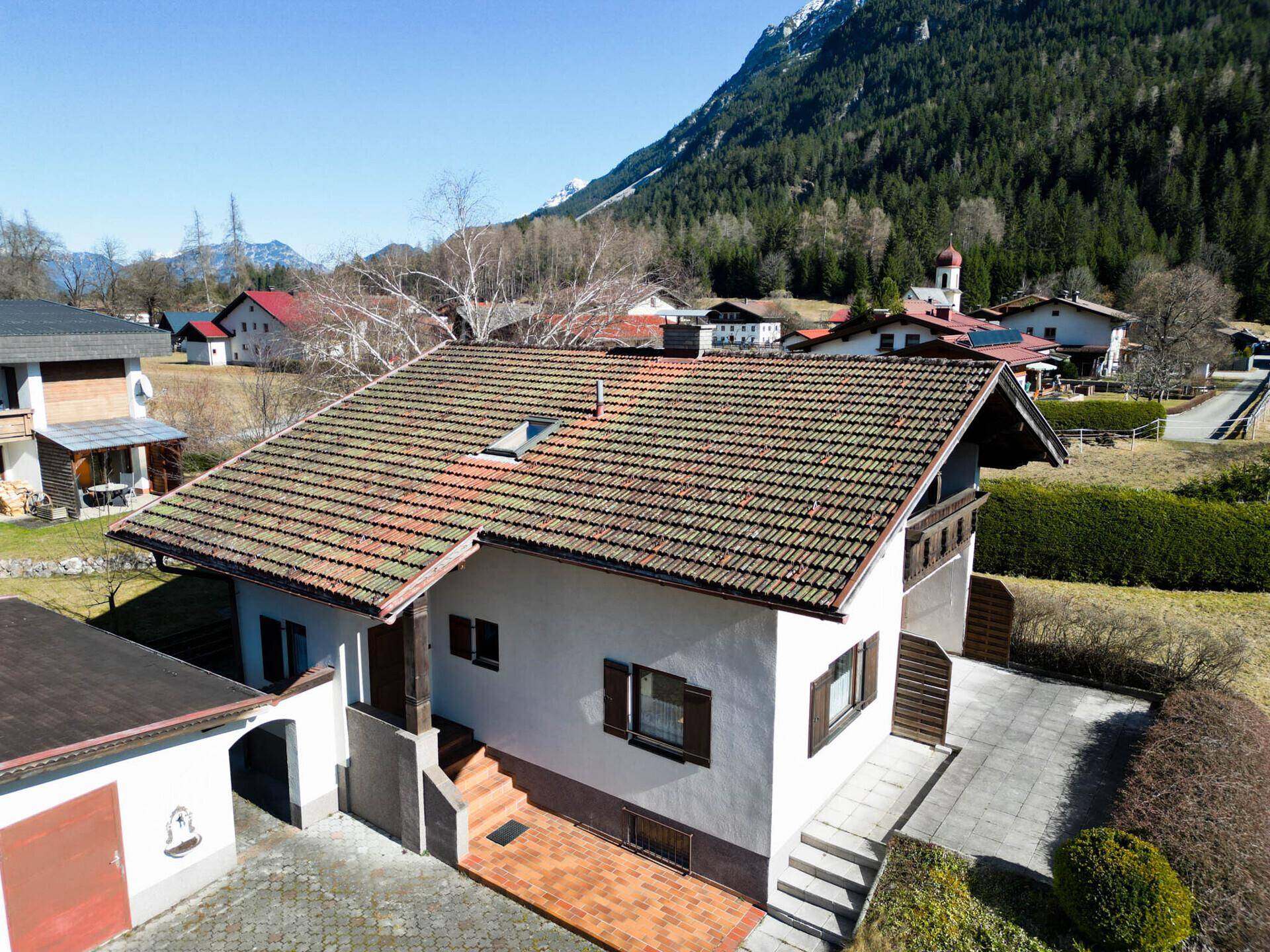 Luftaufnahme des Hauses mit Dach, Garten und umliegender Nachbarschaft.