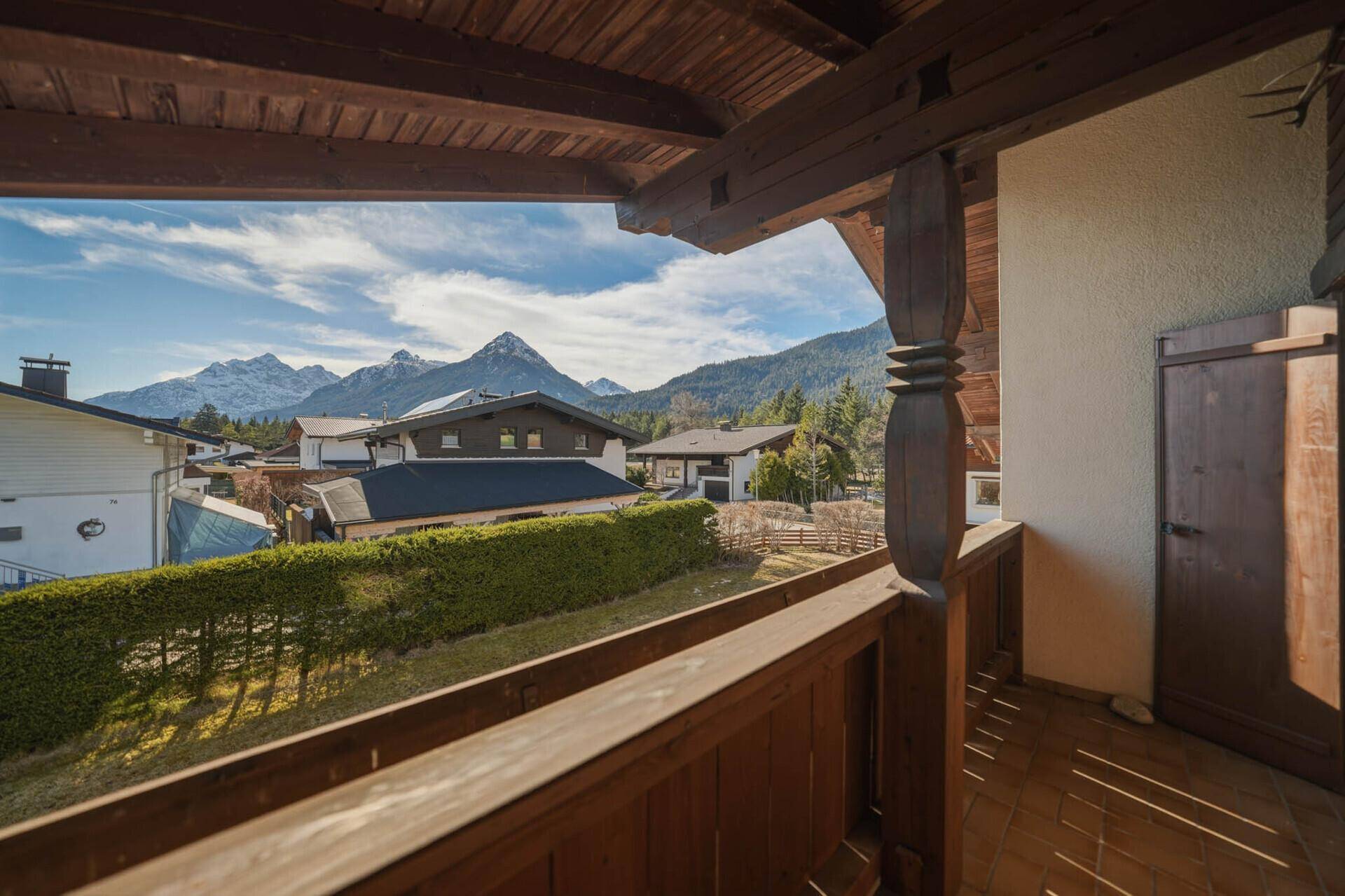 Geräumiger Holzbalkon mit traditionellen Elementen und beeindruckendem Bergblick.