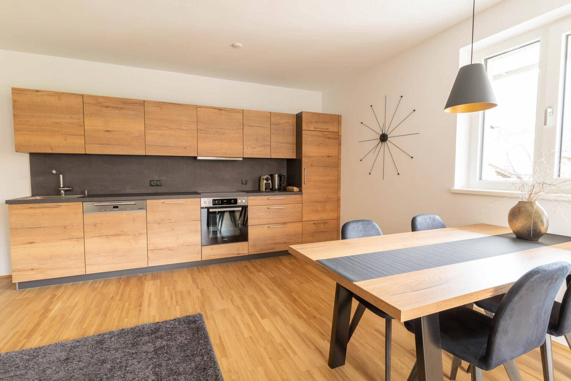 Gemütliches Wohnzimmer mit Sofa, Couchtisch und Zugang zum Balkon.