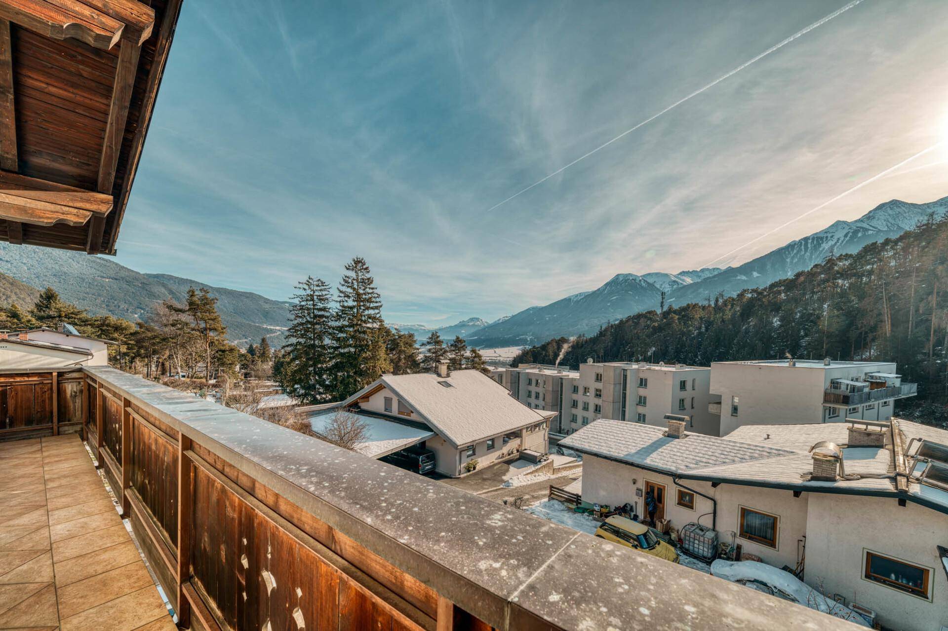 Balkon mit weitem Blick auf die verschneite Landschaft und die umliegenden Gebäude.
