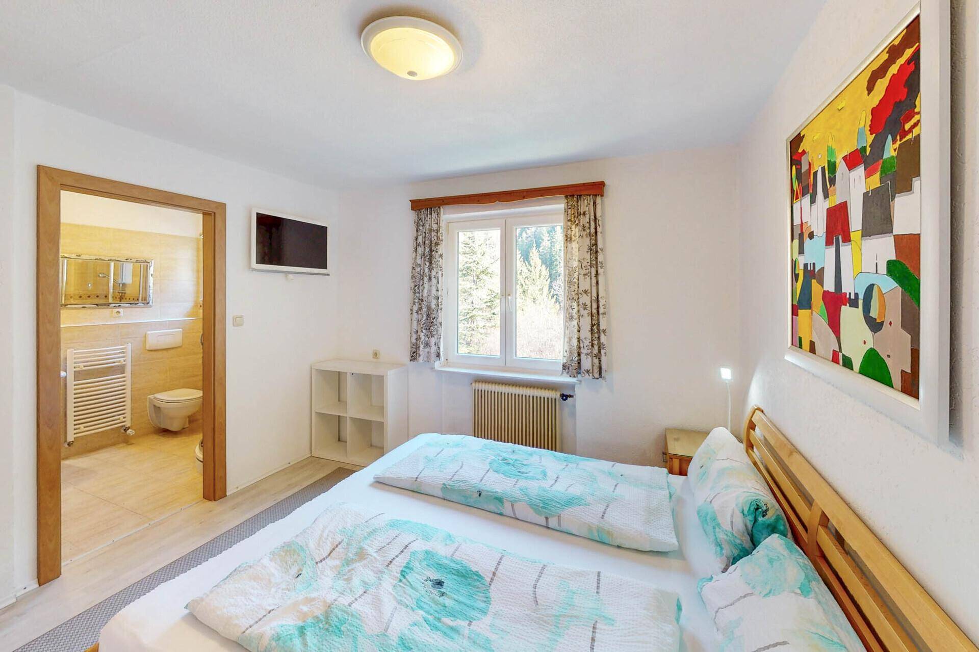 Schlafzimmer mit Doppelbett und direktem Zugang zu einem Badezimmer.