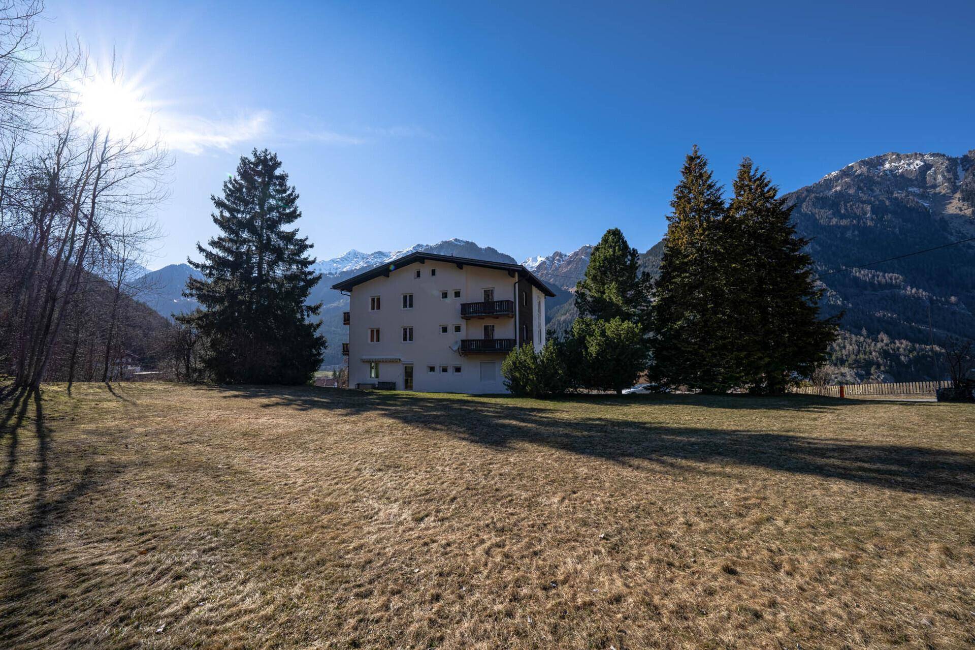 Großes Grundstück mit viel Grünfläche und Blick auf die Berge.