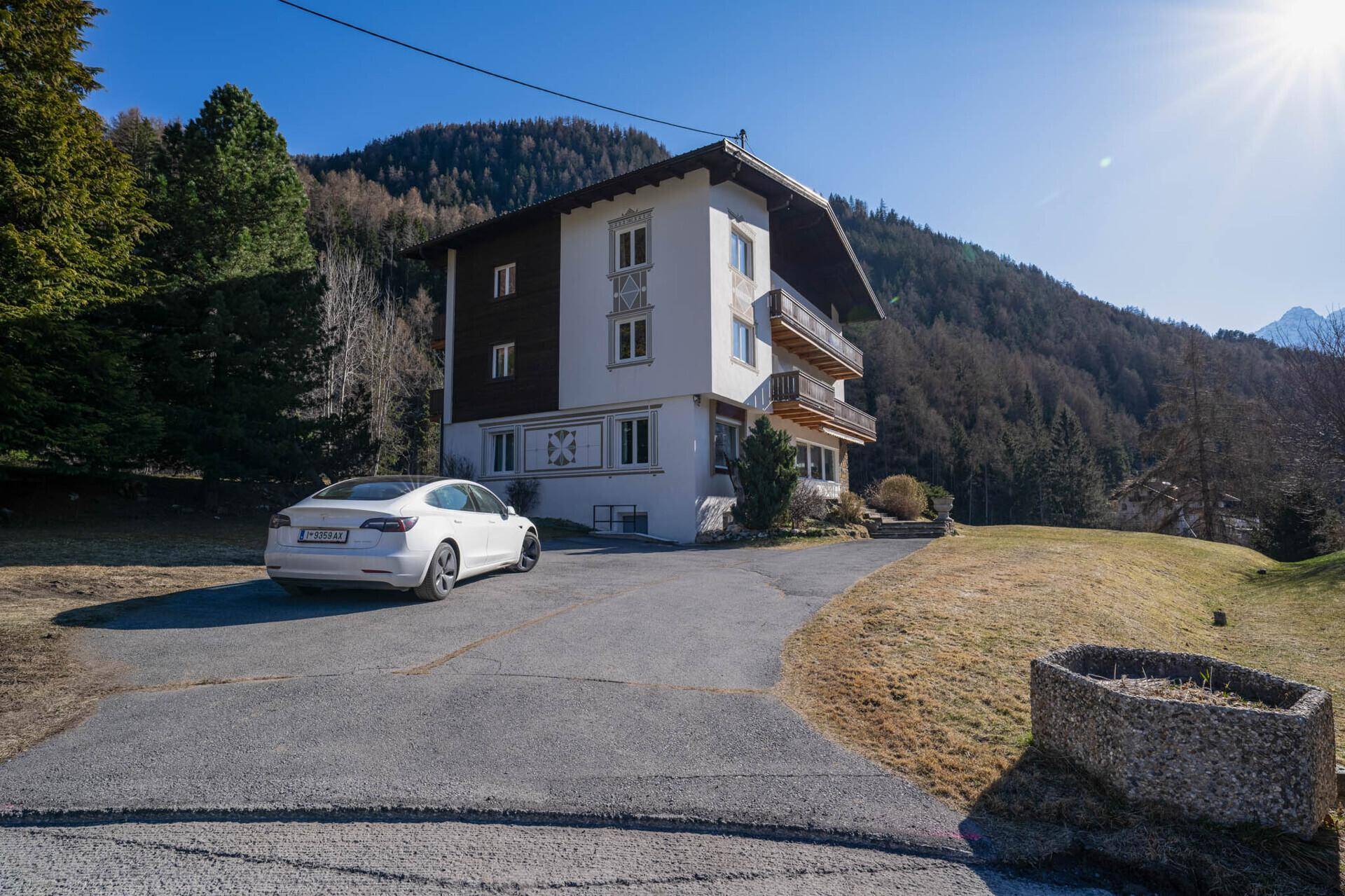 Großzügiges Wohnhaus in alpiner Umgebung mit umliegenden Wäldern und Bergen.