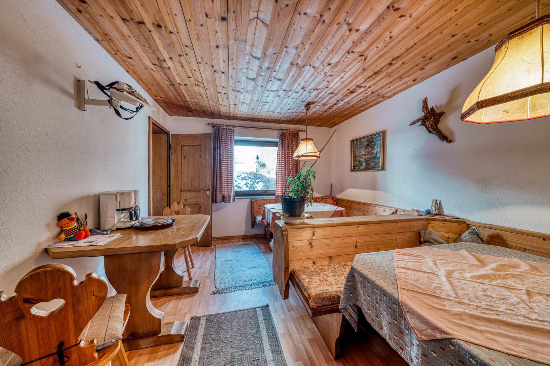 Gemütlicher Essbereich mit Holzbänken, Holztisch und traditioneller Einrichtung.