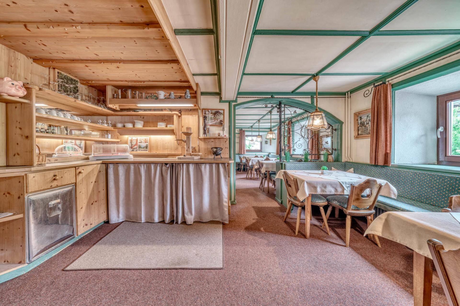 Speisesaal mit Buffetbereich, Holztäfelung und traditionellen Sitzgelegenheiten.