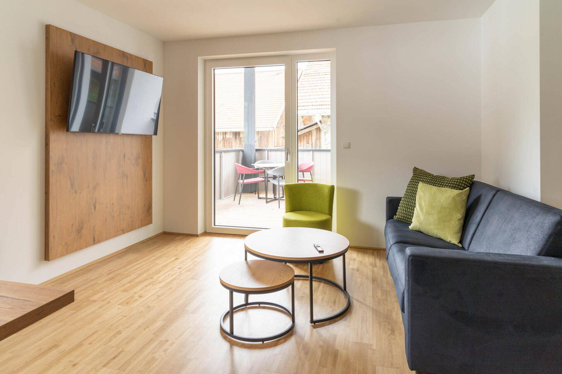 Helles Schlafzimmer mit Doppelbett, Holzboden und dekorativer Wandgestaltung.