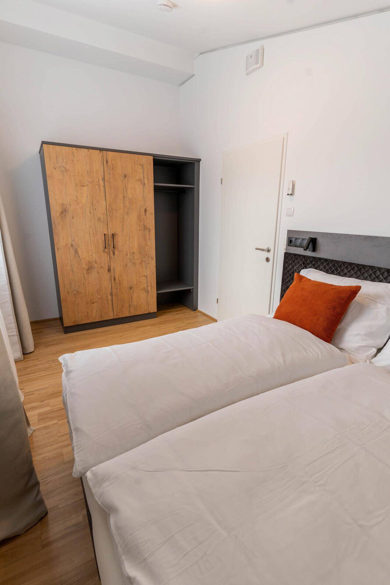 Modernes Gäste-WC mit kleinem Waschbecken und dunklen Bodenfliesen.