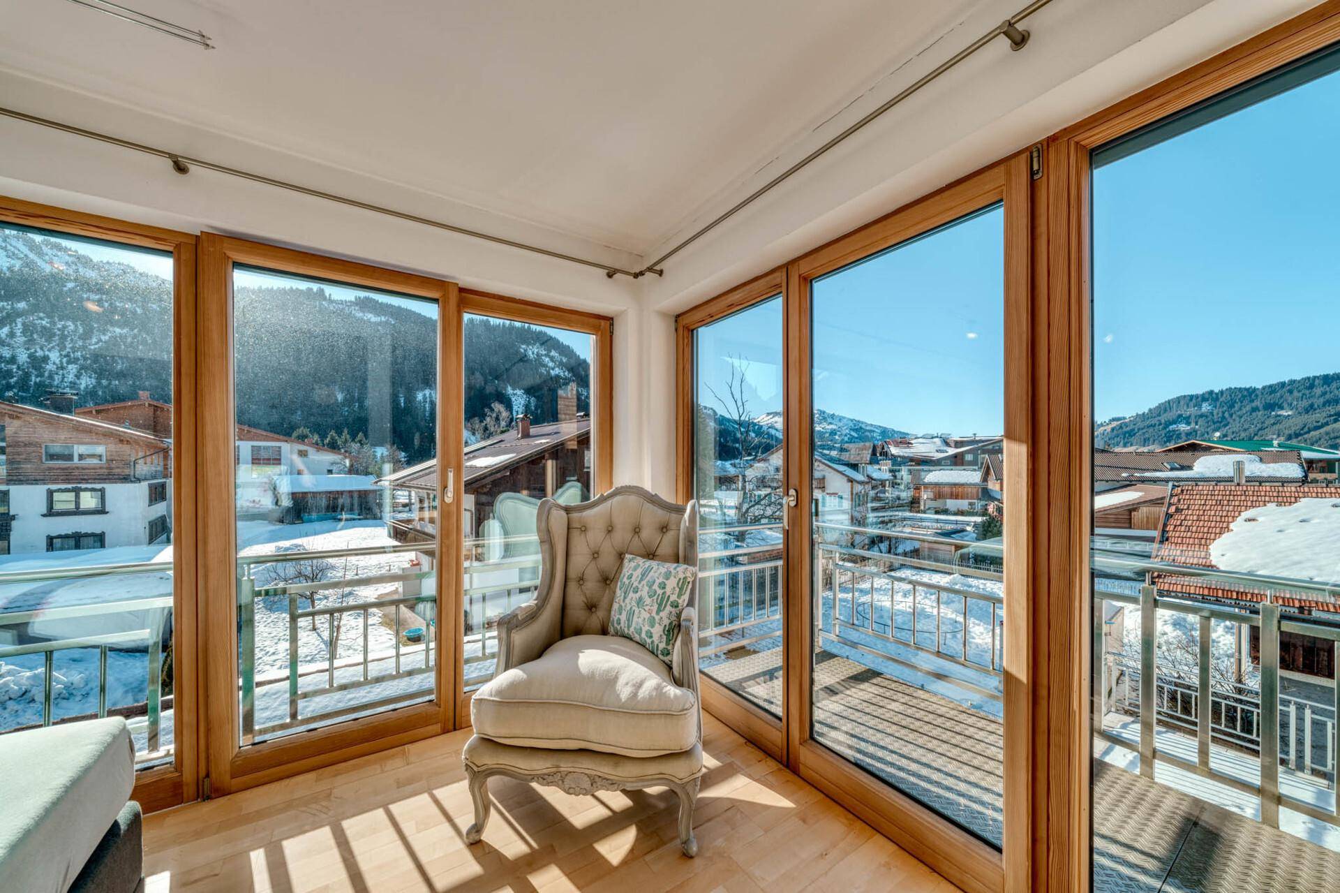Gemütliche Sitzecke im Schlafzimmer mit Sessel und weitem Blick auf die Berge.