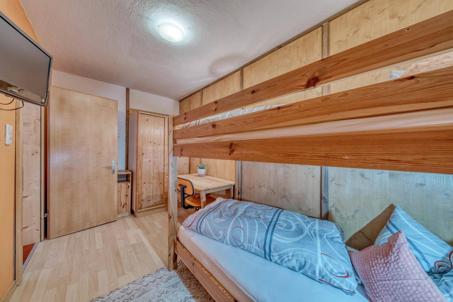 Schlafzimmer mit Etagenbett und Holzboden, ideal für Kinder oder Gäste.