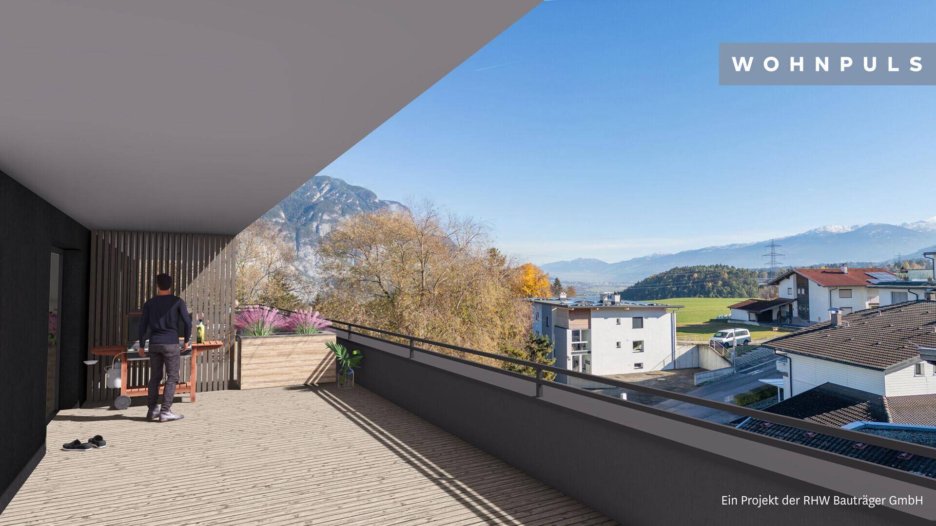 Geräumiger Balkon mit Holzboden und weitem Blick auf die umliegende Berglandschaft.