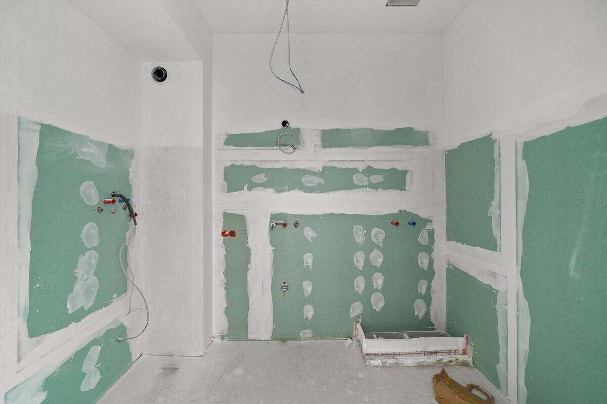 Badezimmer im Ausbau mit sichtbaren Installationen und viel Platz für moderne Ausstattung.