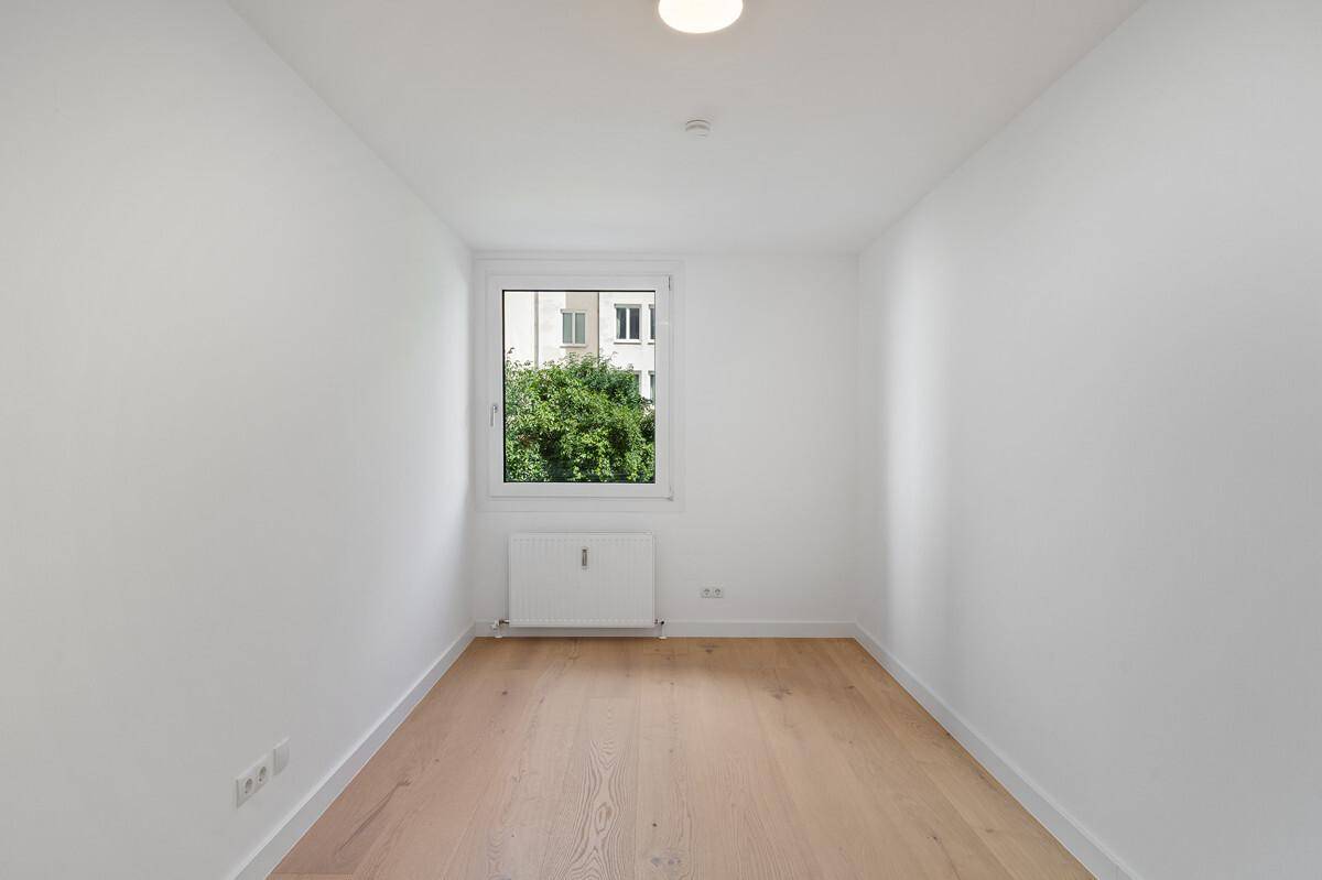 Kleineres Zimmer mit Parkettboden und Fenster, ideal als Kinder- oder Arbeitszimmer.