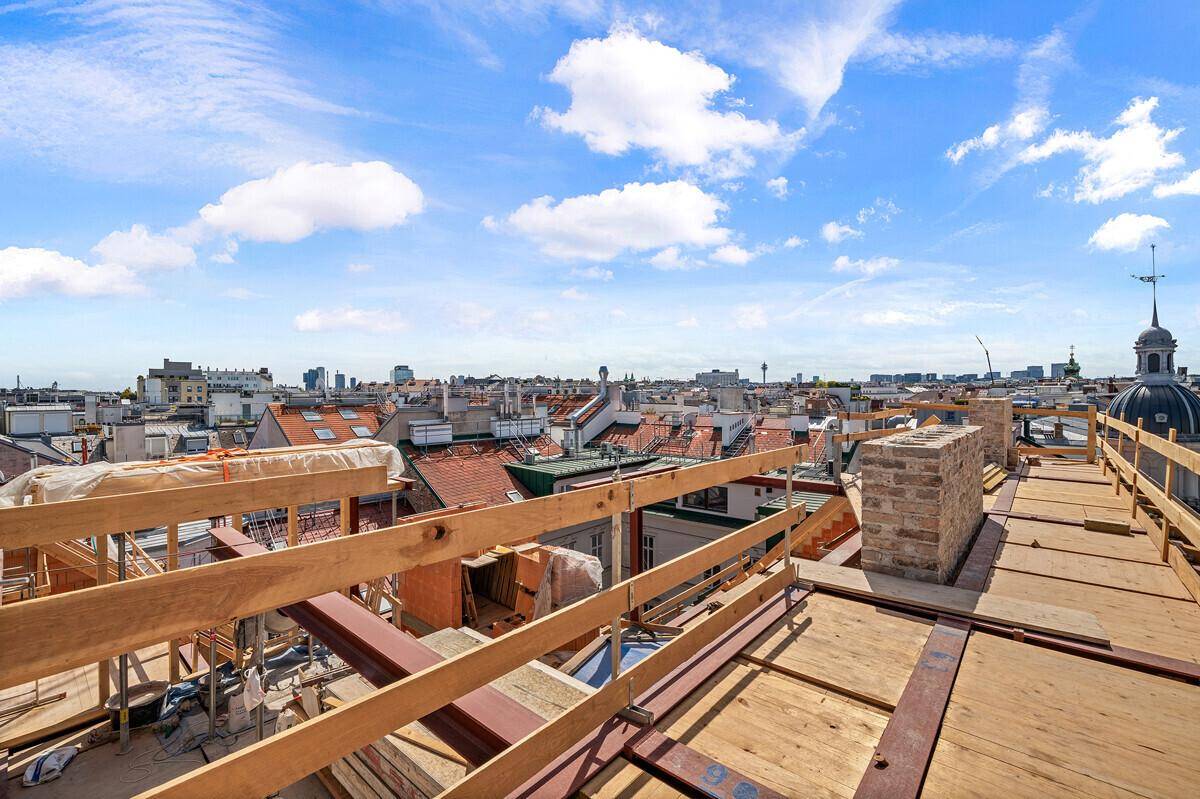 Dachbaustelle mit Holzkonstruktion und weitem Blick über die historischen Dächer der Stadt.