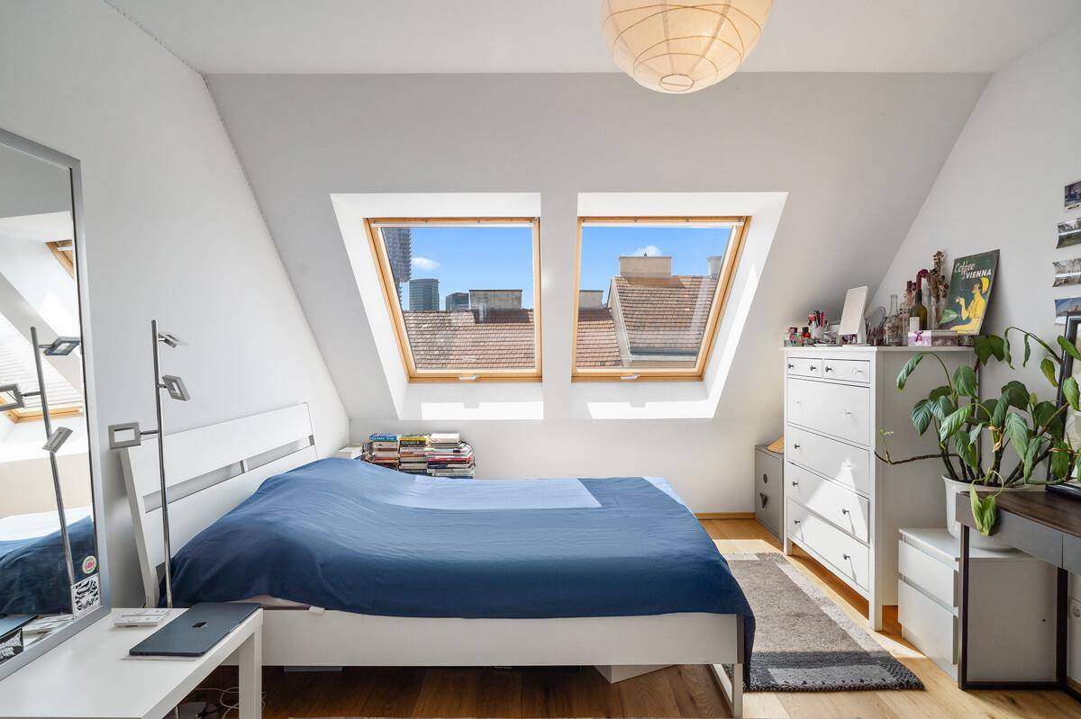 Geräumiges Schlafzimmer im Dachgeschoss mit Doppelbett und Dachfenstern.