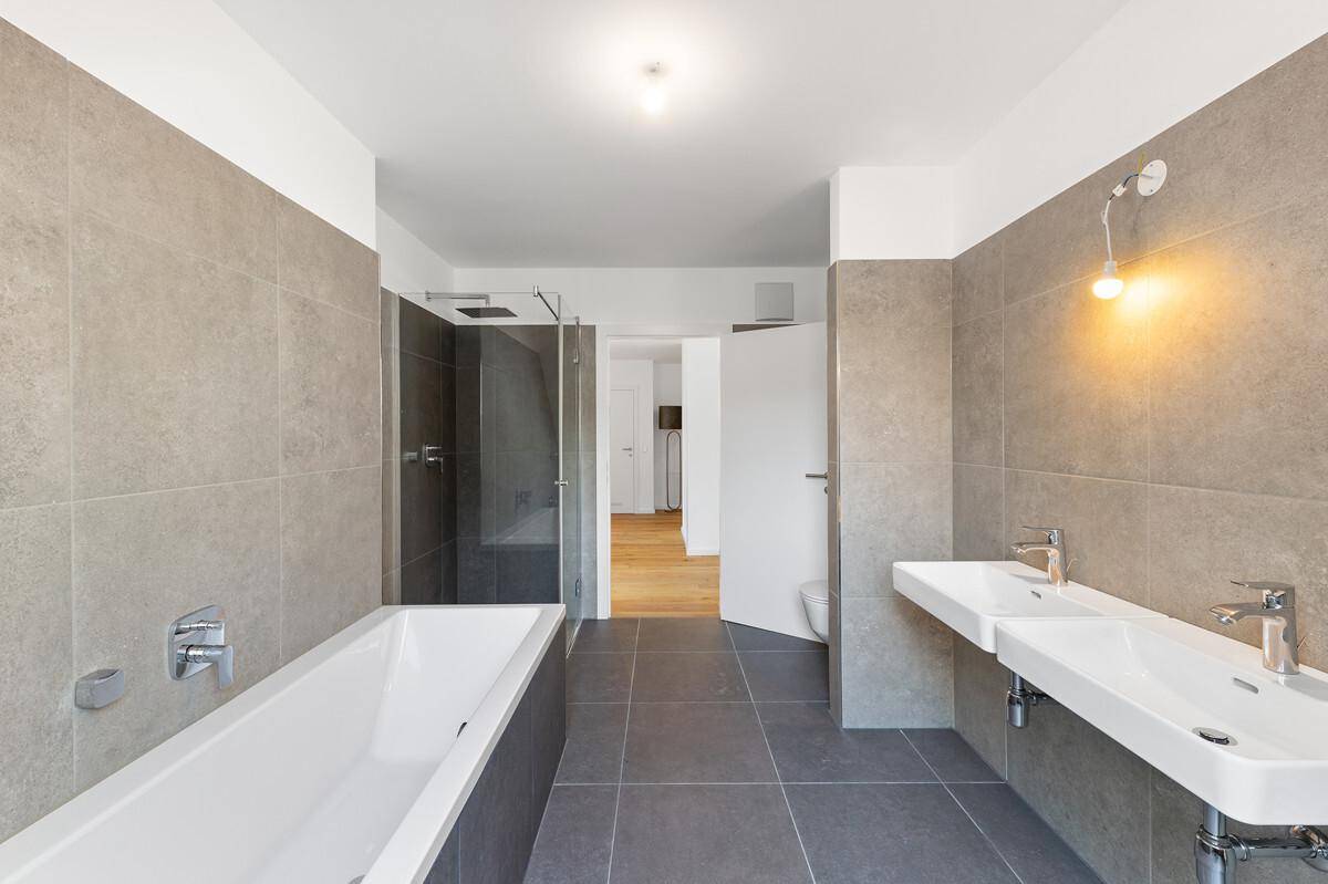 Modernes Badezimmer mit Doppelwaschbecken, Badewanne und begehbarer Dusche.